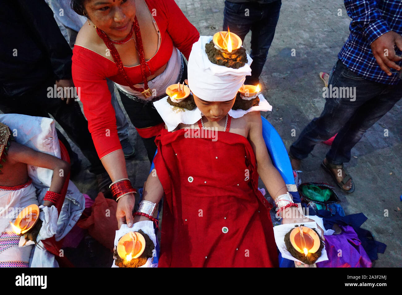 Bhaktapur, Népal. 8 octobre, 2018. Une femme népalaise lights lampes à huile sur le corps d'un hindou dévot pendant le festival.Dashain est célébré pour marquer la victoire d'après des écrits religieux hindou de Ramayan sur le mal roi démon Ravana et plus le démon Mahisasur qui terrorise les habitants de cruellement dans l'Inde sous forme d'un buffle d'eau qui fait rage. Credit : Sunil Pradhan SOPA/Images/ZUMA/Alamy Fil Live News Banque D'Images