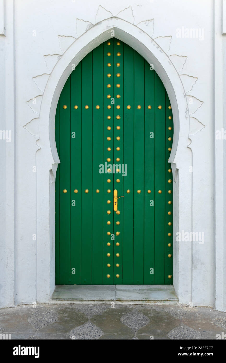 Porte en bois peint en vert avec une décoration aux couleurs de l'or dans la médina d'Asilah, Maroc Banque D'Images