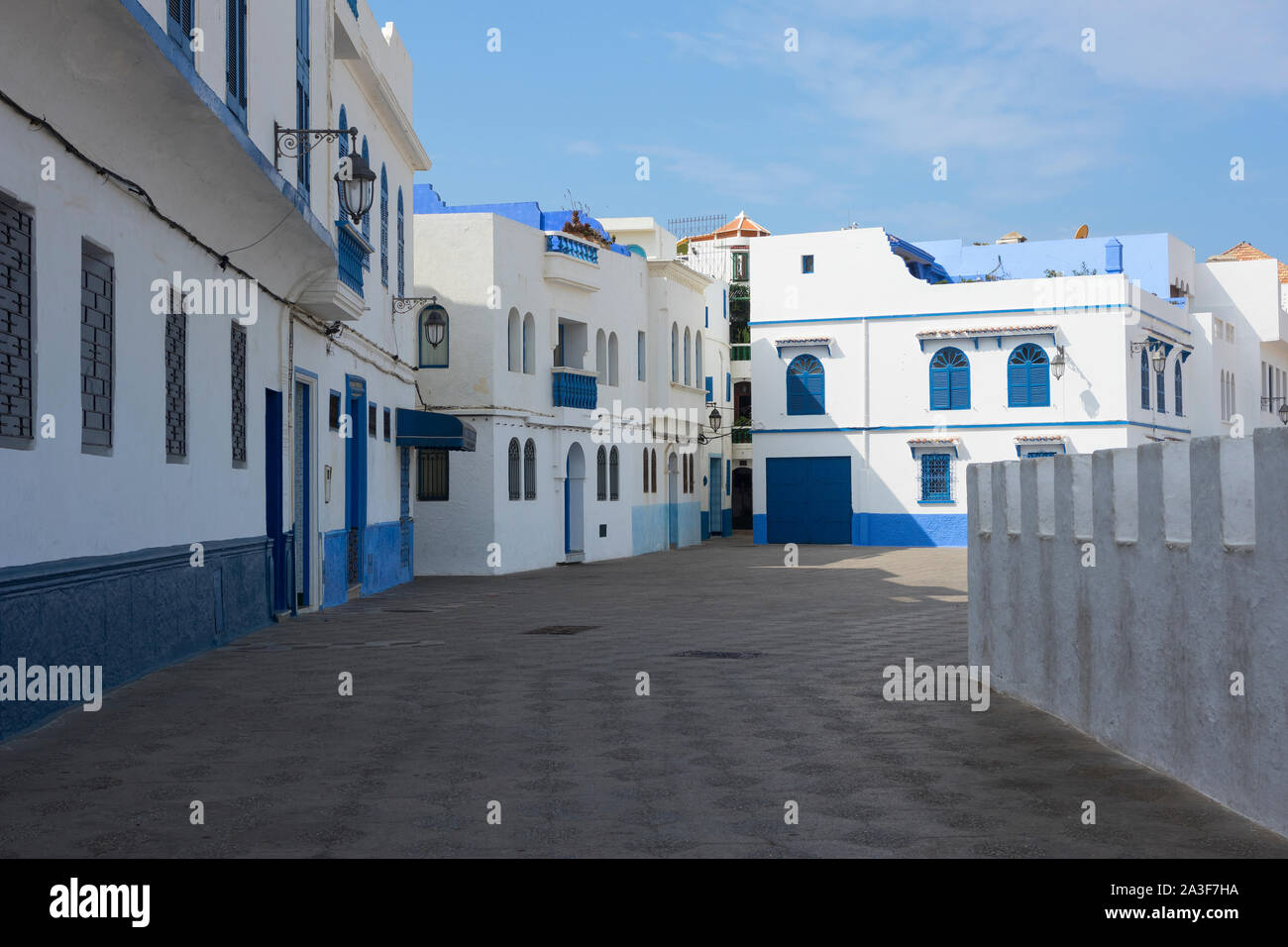 Old street dans la médina d'Asilah avec d'un côté le rempart de pierre de la plage Banque D'Images