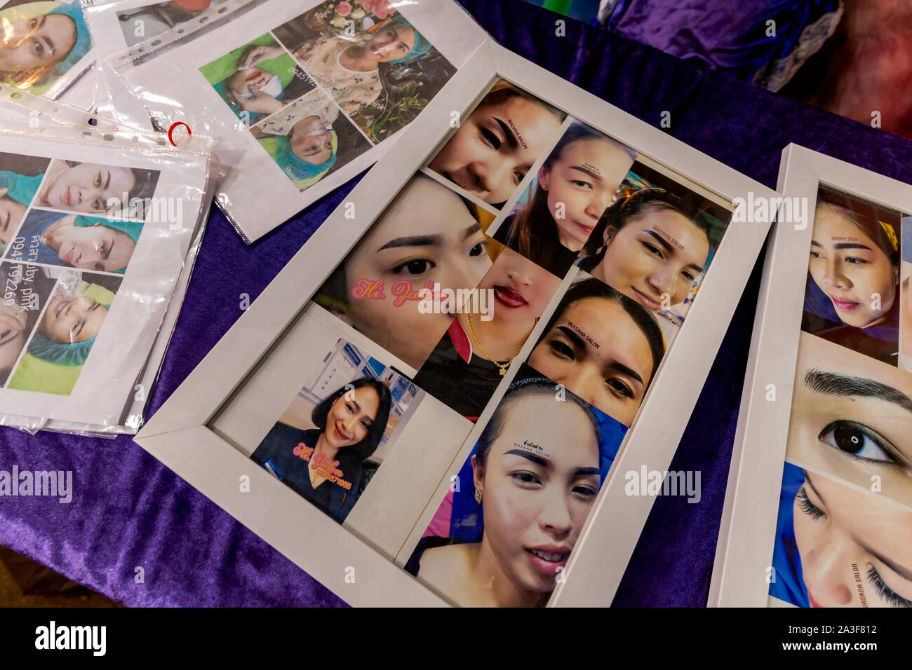 Photos de femmes avec des sourcils permanents reste sur une table à une foire commerciale dans la région de Kampong Cham, au Cambodge. Banque D'Images