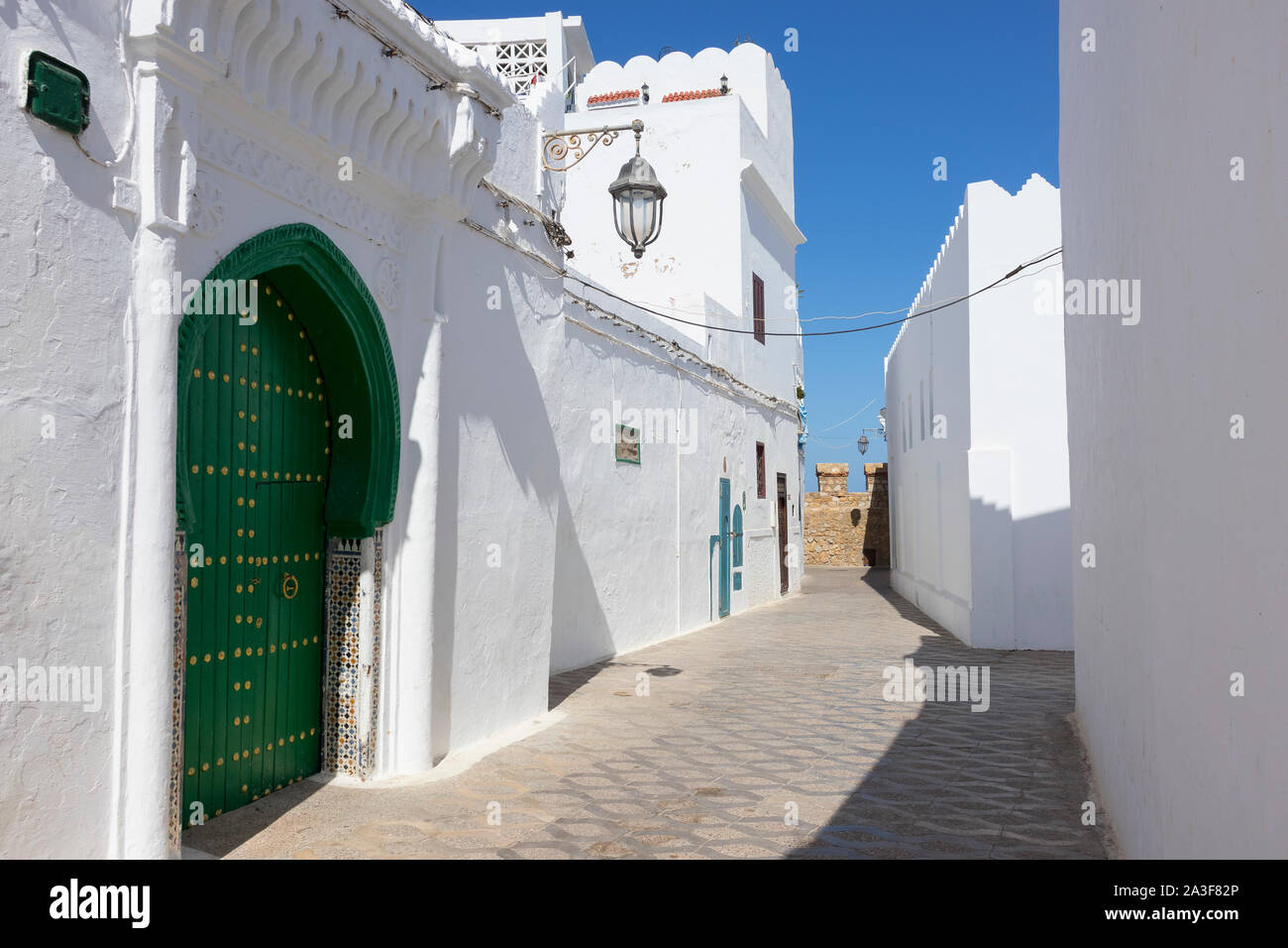 Classic Old street dans la médina d'Asilah avec le mur de rempart à la fin de la rue, le nord du Maroc Banque D'Images