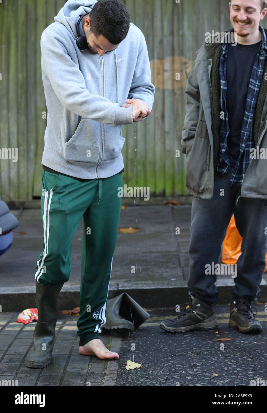 Un résident regarde ses pieds mouillés après une rue de Finsbury Park, au nord de Londres, inondé lorsque un tuyau éclaté mardi matin. Banque D'Images