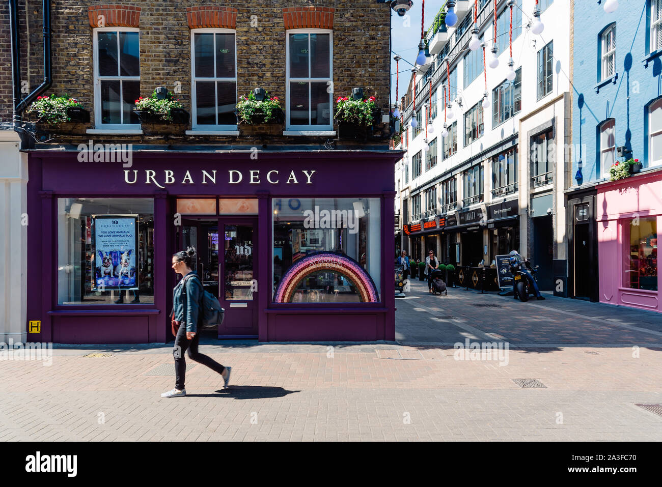 Londres, Royaume-Uni - 15 mai 2019 : Urban Decay cosmetics boutique ferme à Carnaby Street à Londres. Femme non identifiée sur le premier plan Banque D'Images