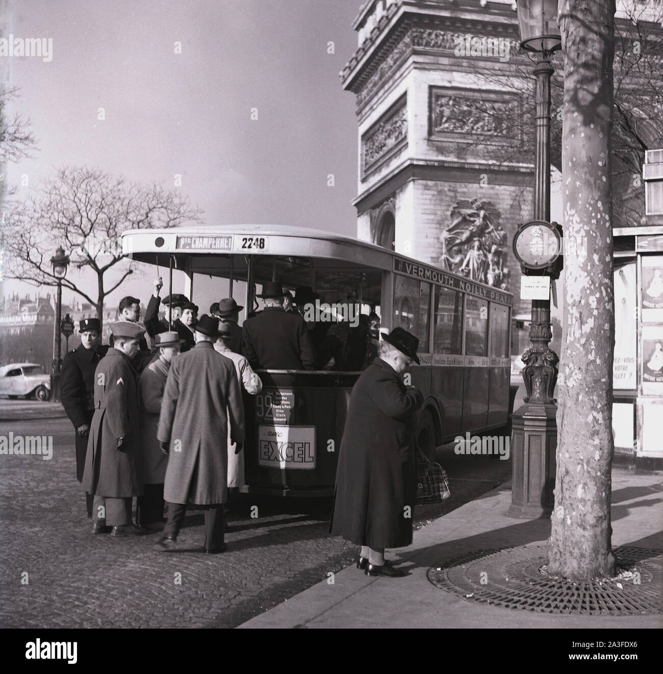 Années 1950, historiques, les gens boaring un simple-plate 92 bus à l'Arc de Trioumphe, Paris, France. Banque D'Images