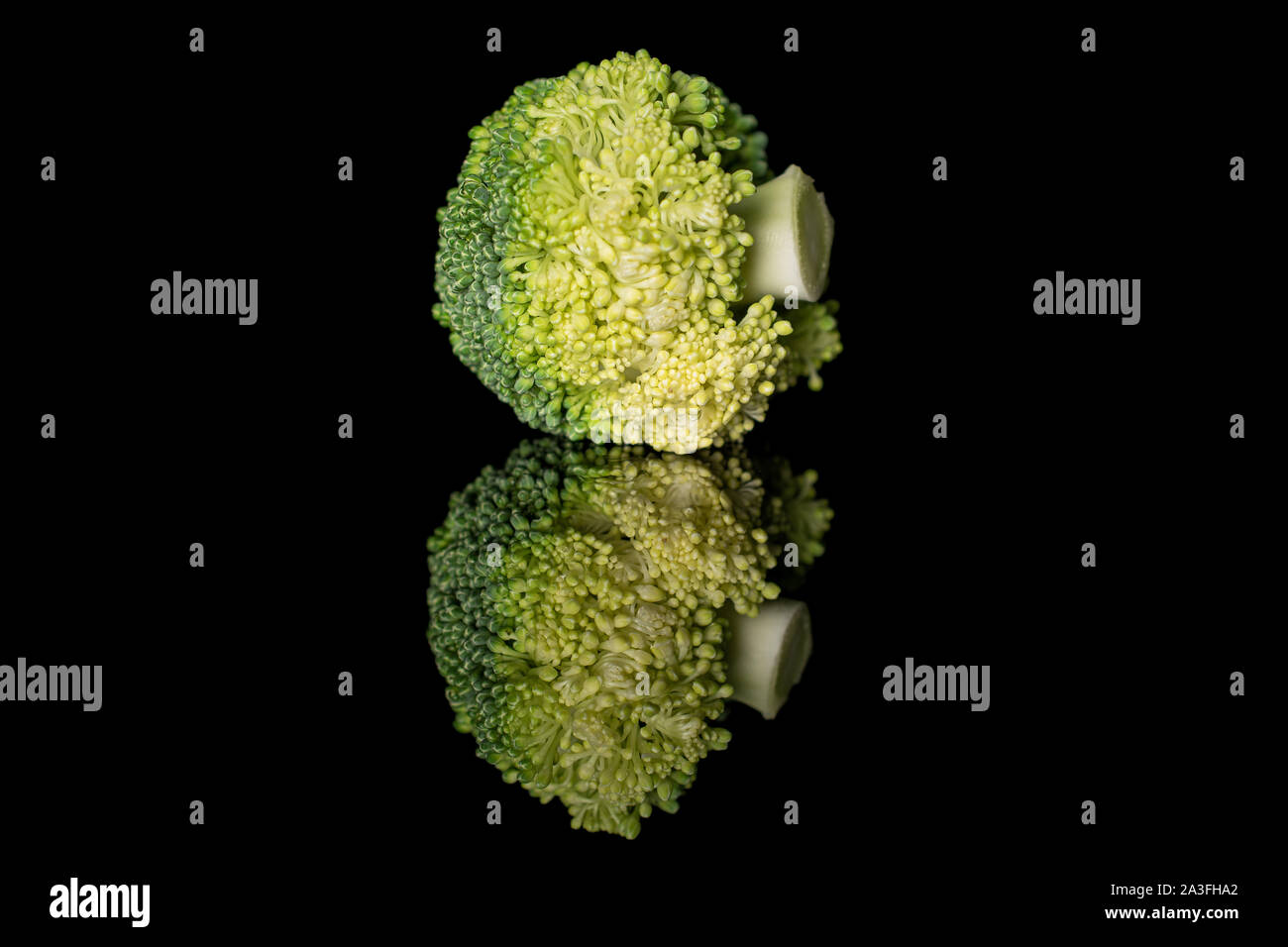 Le brocoli vert frais entier isolé sur verre noir Banque D'Images