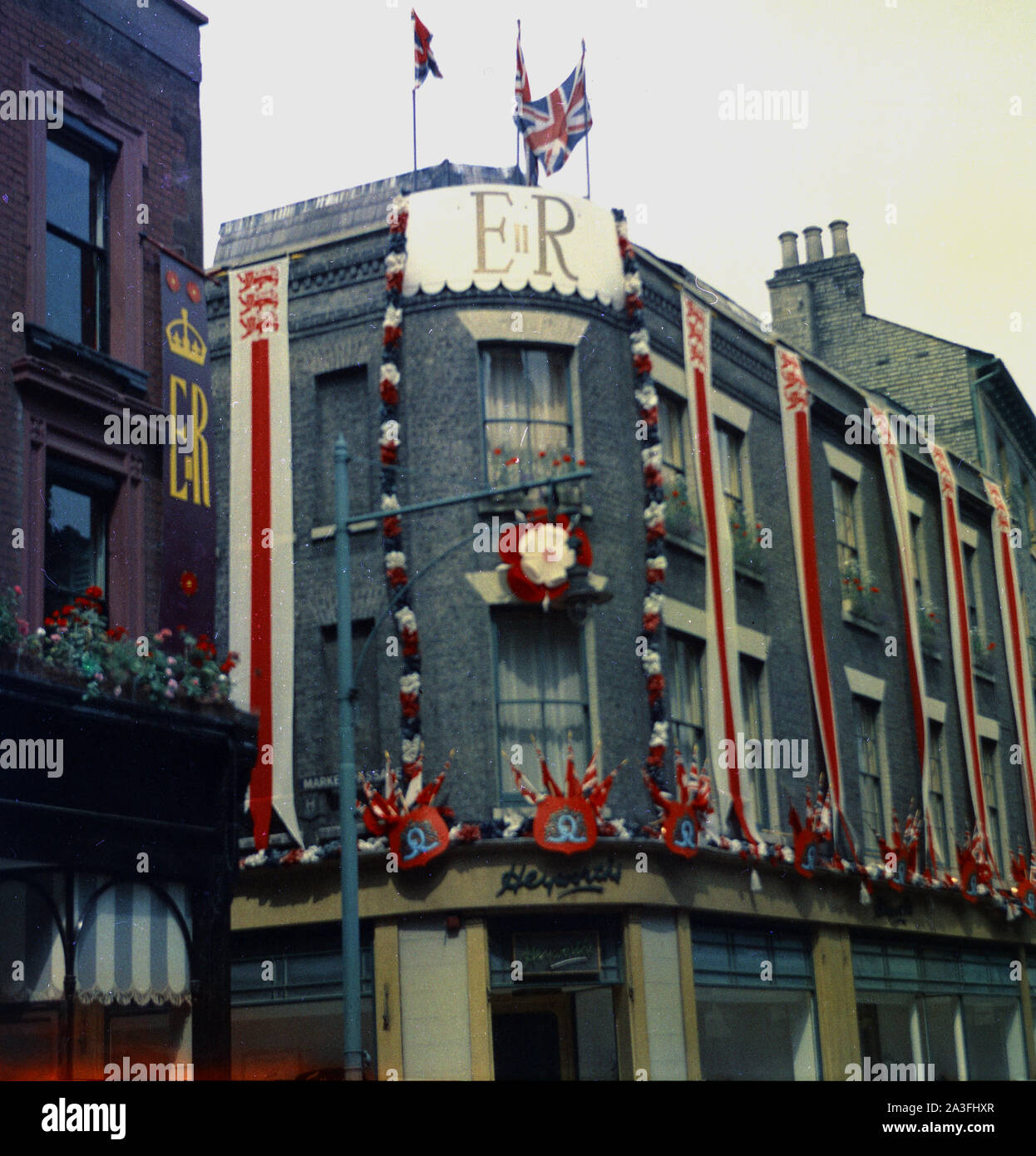 1953, historiques, couronnement de la Reine, l'extérieur de pubs décorés de Union Jack, drapeaux, banderoles et ER bannières, Londres, Angleterre, Royaume-Uni. Le couronnement de la reine Elizabeth II a eu lieu en juin lors de son accession au trône à l'âge de 25 ans après la mort de son père, le roi George VI l'année précédente. Banque D'Images