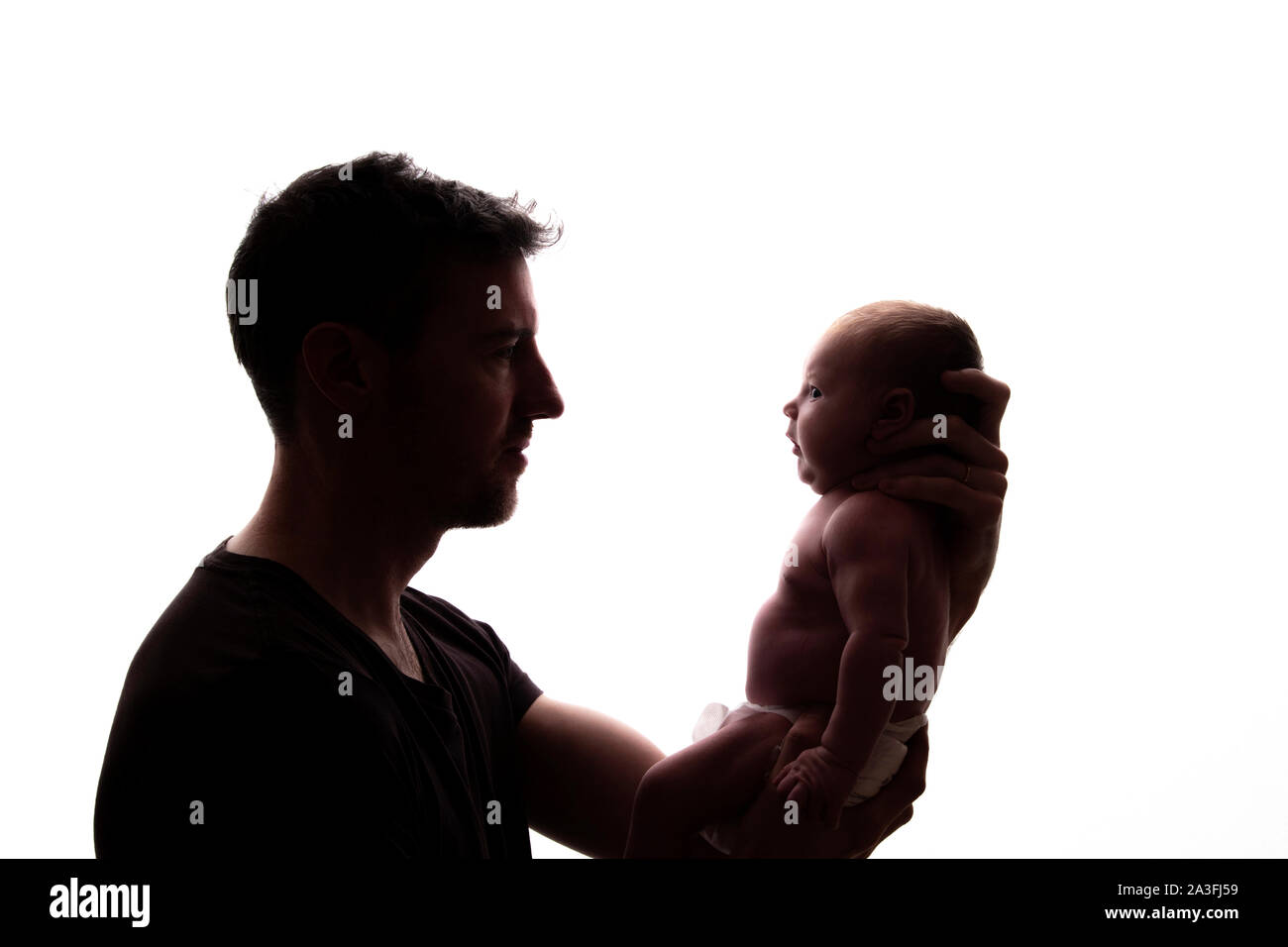 Silhouette d'un père tenant son bébé nouveau-né Banque D'Images