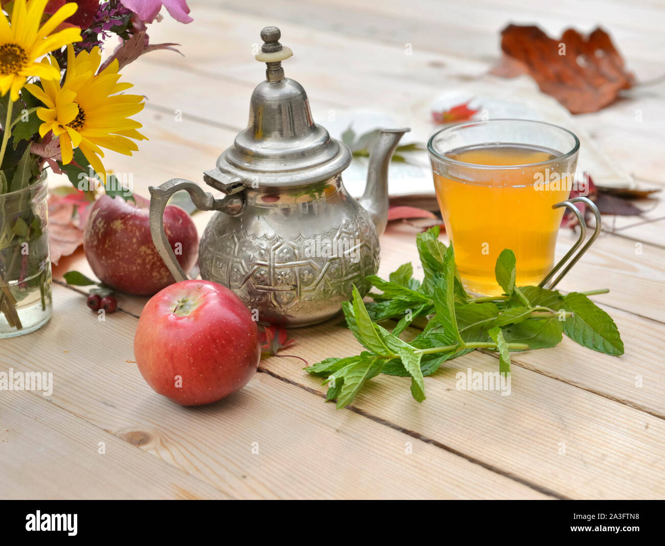 Tasse de thé avec des feuilles de menthe fraîche sur une table en bois dans un décor d'automne Banque D'Images