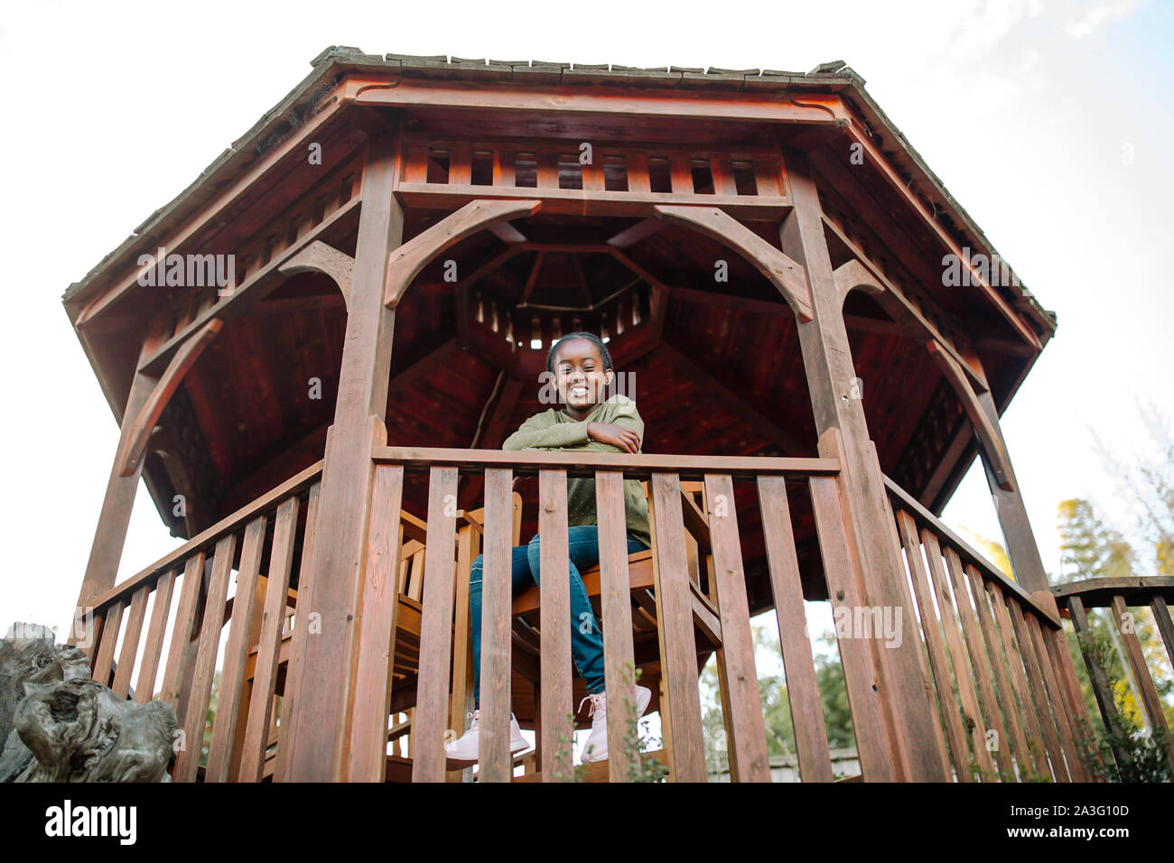 Smiling black girl sitting in gazebo Banque D'Images