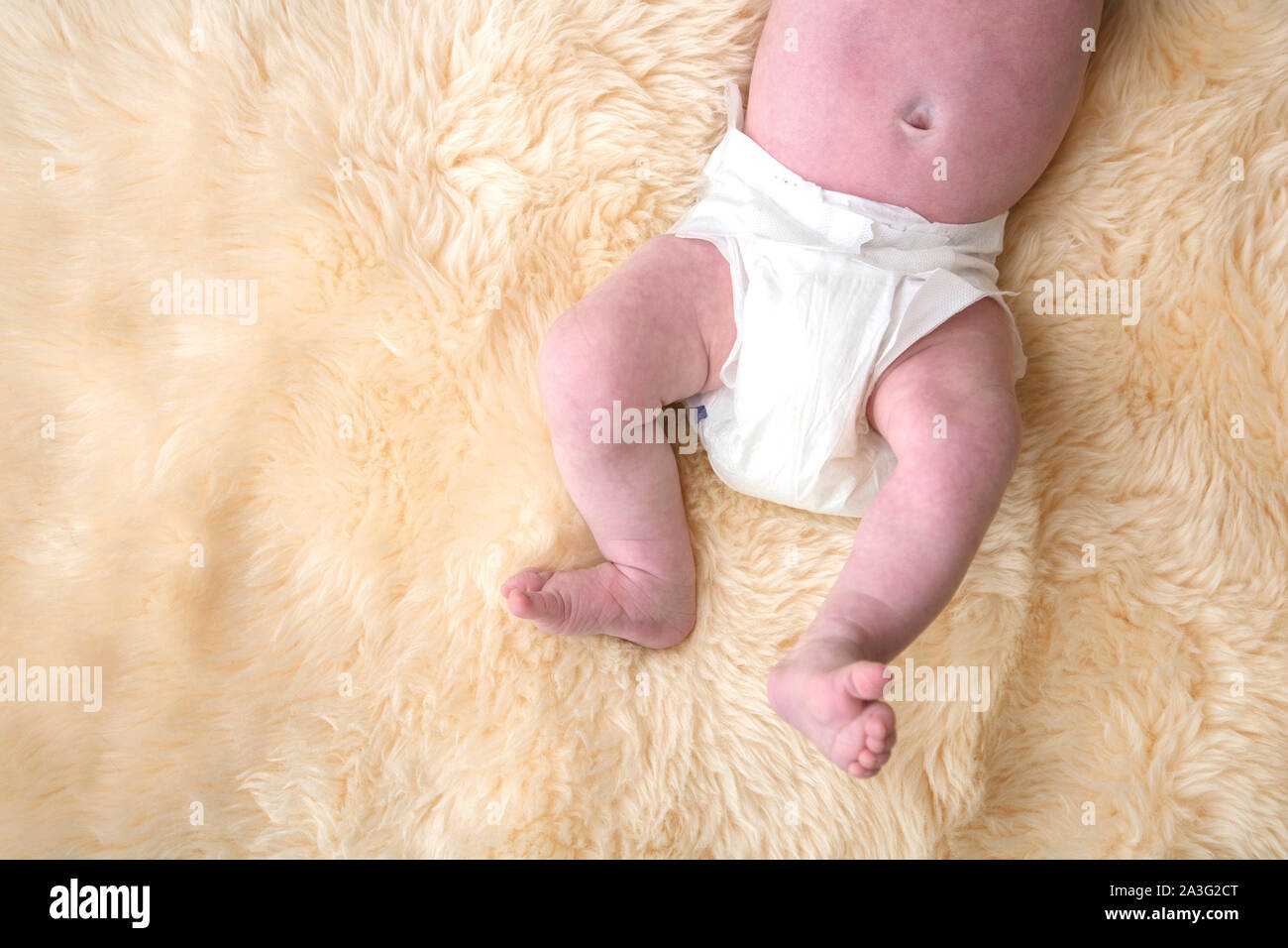 Bébé nouveau-né les jambes avec couche blanche, couche sur un fond de la  fourrure Photo Stock - Alamy