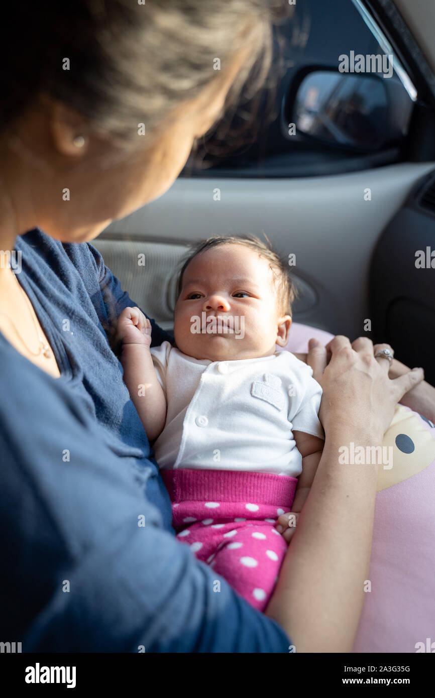 Portrait of infant baby portant sur les genoux de mère tandis que dans la voiture Banque D'Images