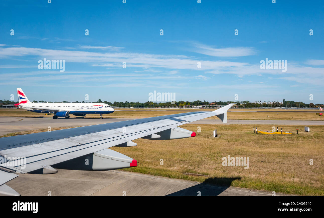 Vue depuis la fenêtre de l'avion de la piste avec British Airways avion au sol, l'aéroport de Heathrow, Londres, Angleterre, Royaume-Uni Banque D'Images
