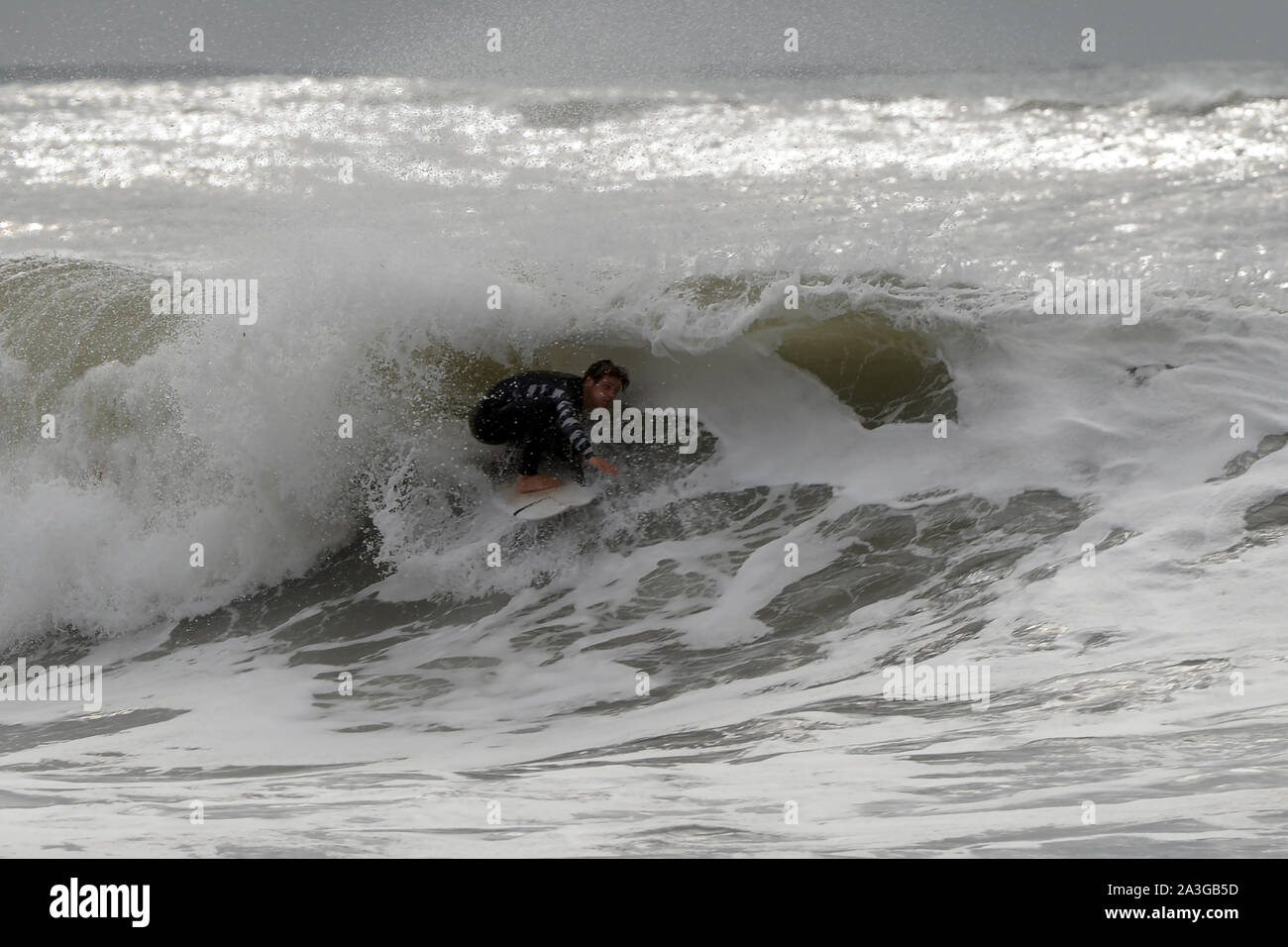 En passant pour le tube sur une vague surfer Patrick Langdon au beurre noir la formation au Pays de Galles Banque D'Images