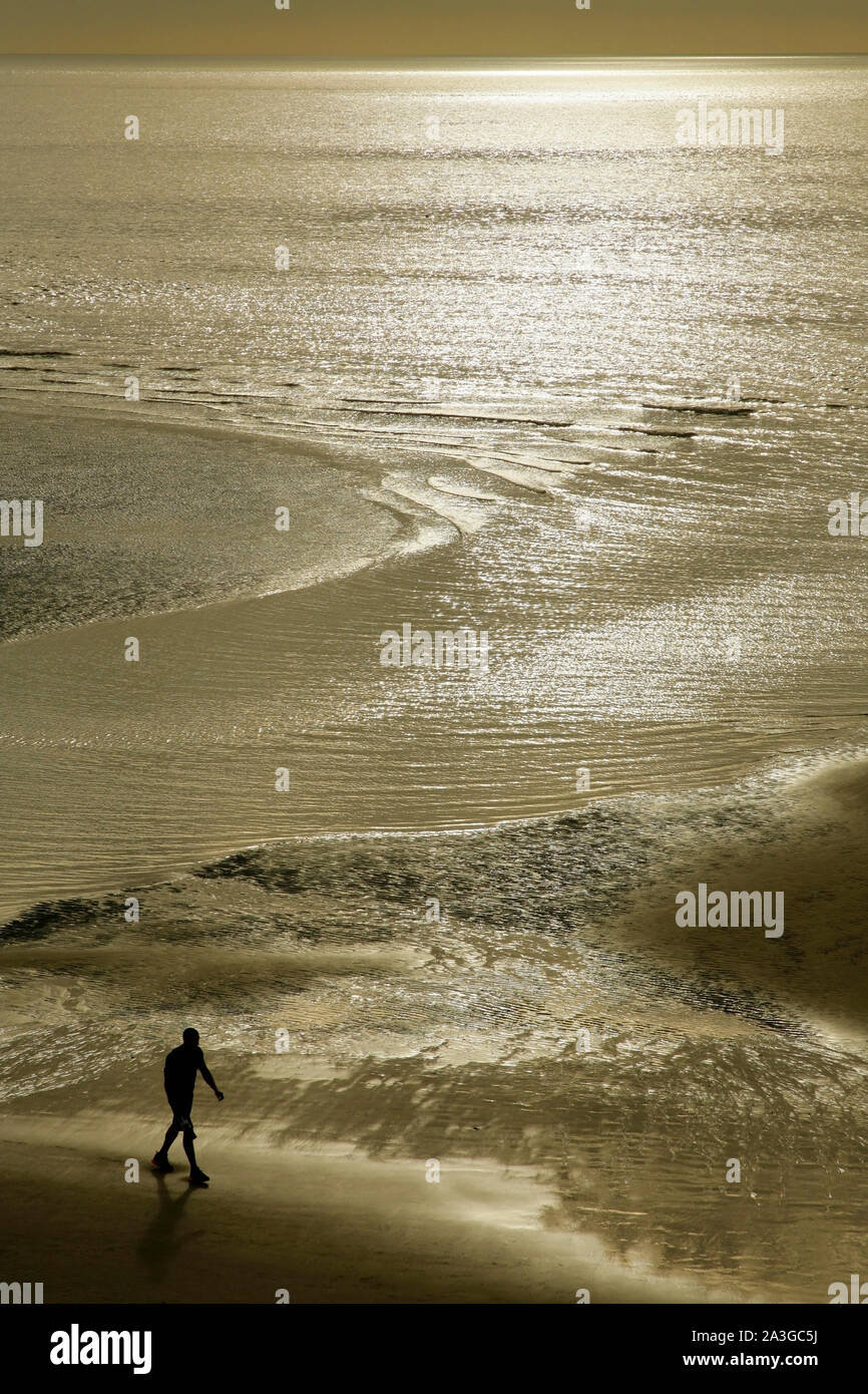 Homme marchant le long de la plage de Blackpool, à marée basse. Banque D'Images