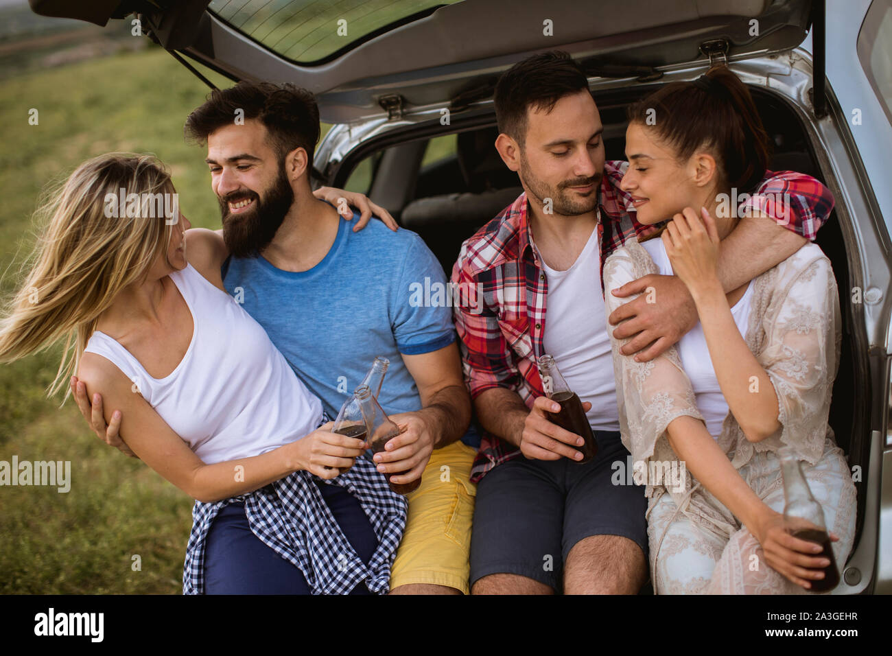 Groupe de jeunes gens assis dans la voiture lors d'un voyage dans l'trank nature Banque D'Images