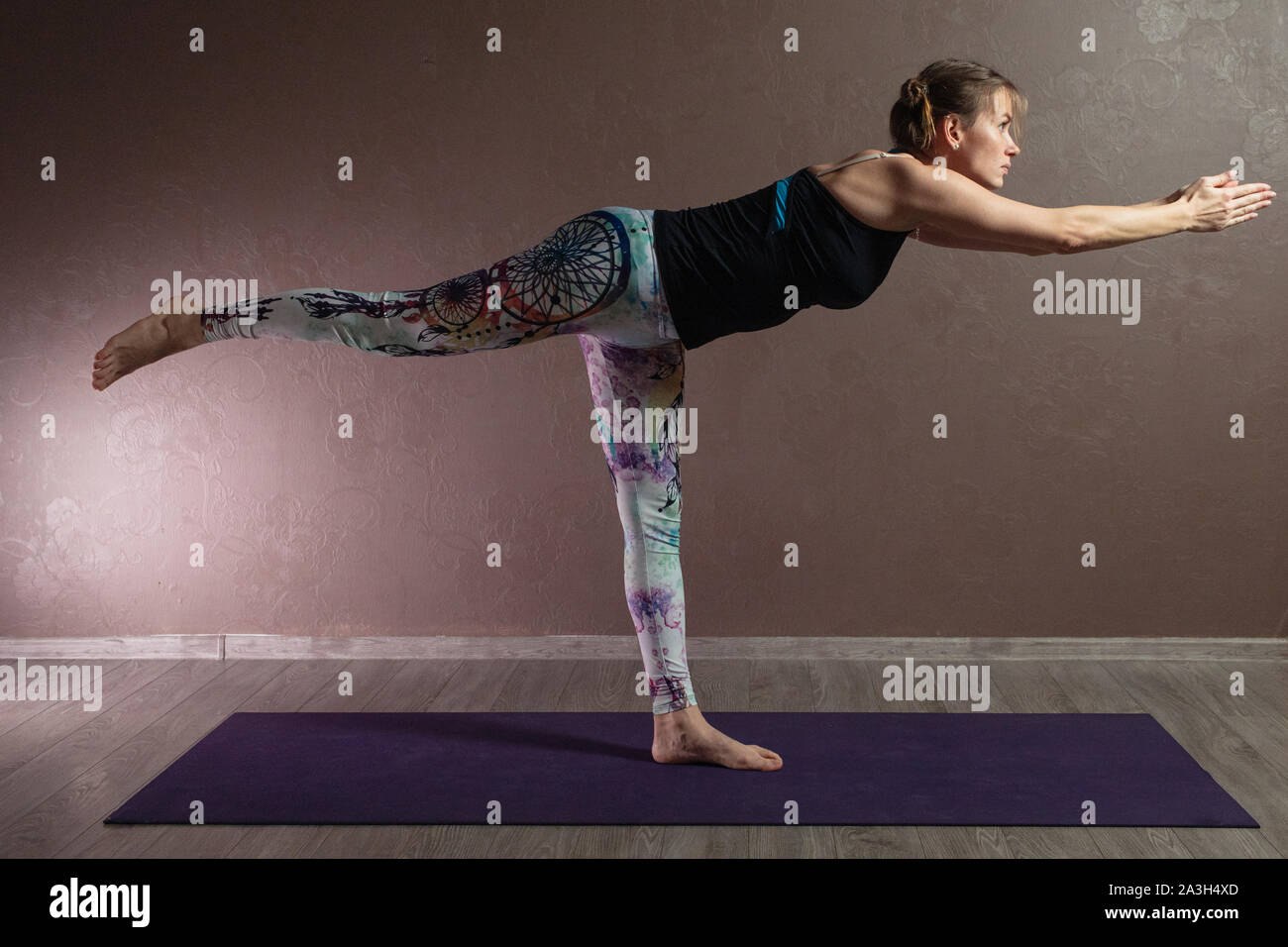 Young attractive woman practicing yoga, méditation, yoga, le port de vêtements de sport, piscine pleine longueur, brown yoga studio Banque D'Images
