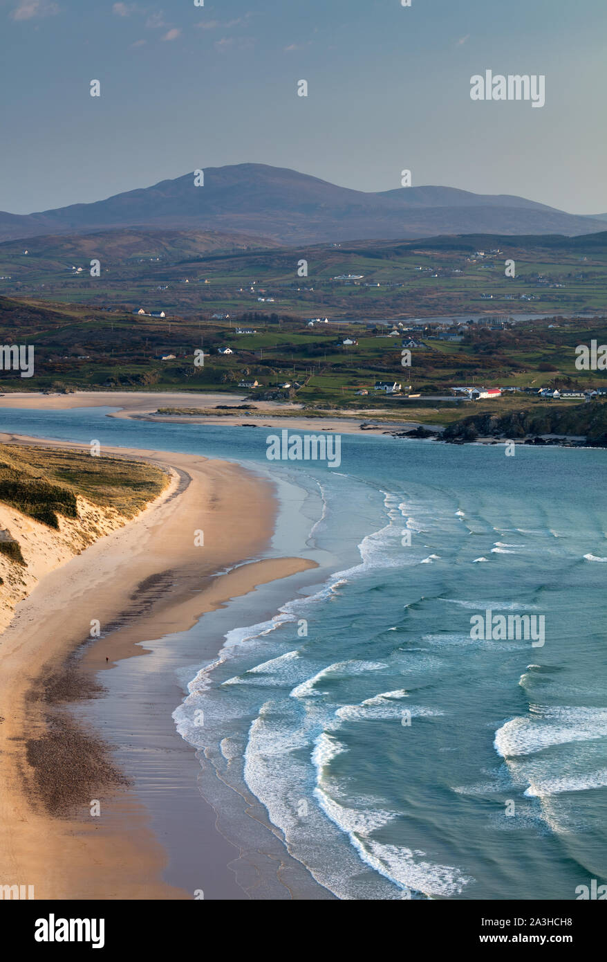 Une figure solitaire sur cinq doigts Strand, Trawbreaga Bay et Dunaff Head de soldats Hill, péninsule d'Inishowen, Co Donegal, Irlande Banque D'Images