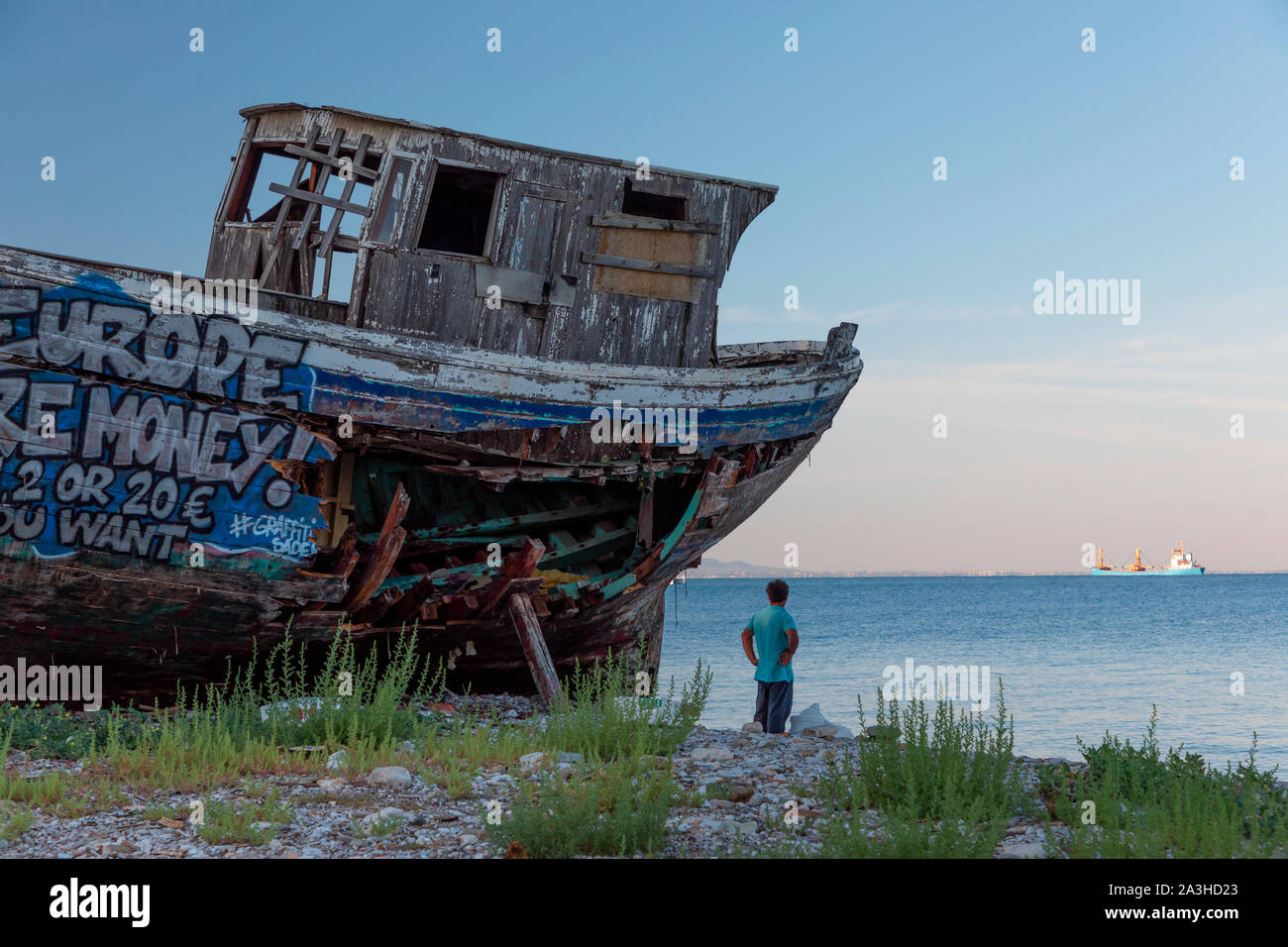 Un vieux bateau de pêche en bois couvert de graffitis sur cale sèche. Banque D'Images