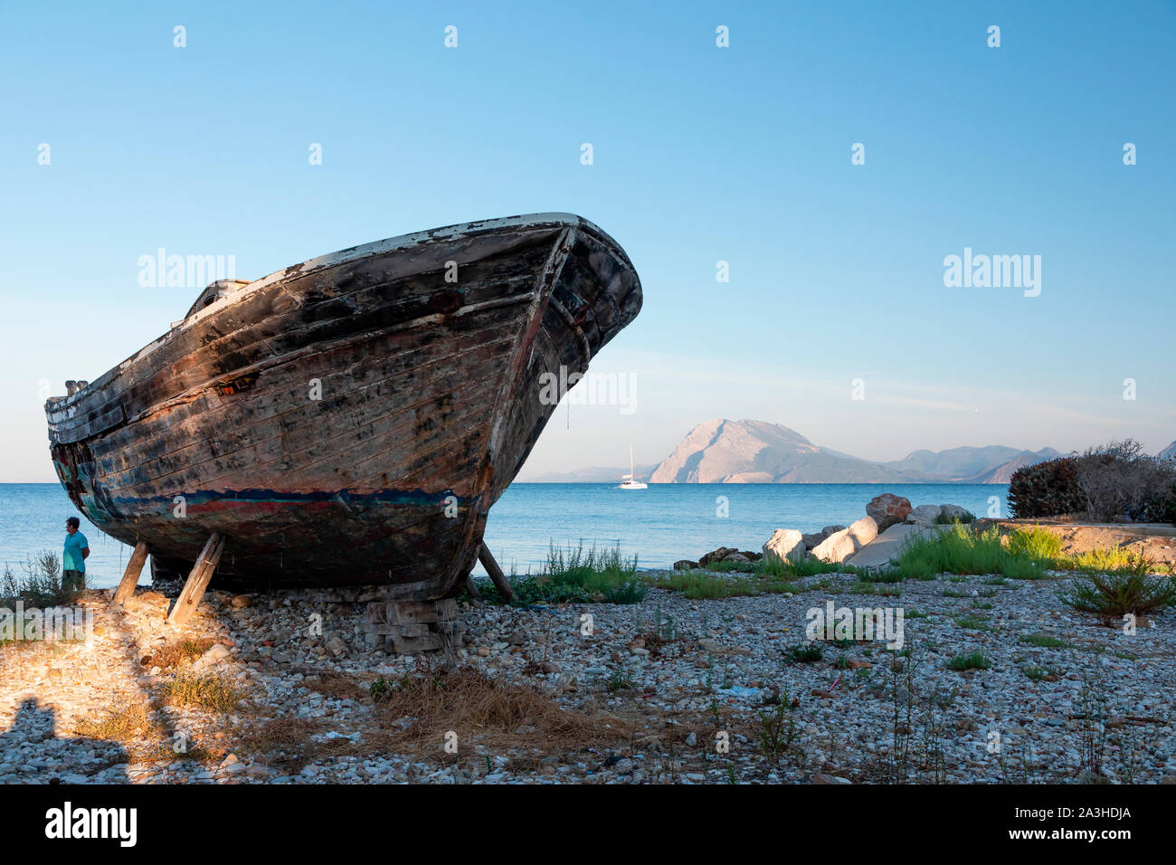 Un vieux bateau de pêche en bois couvert de graffitis sur cale sèche. Banque D'Images