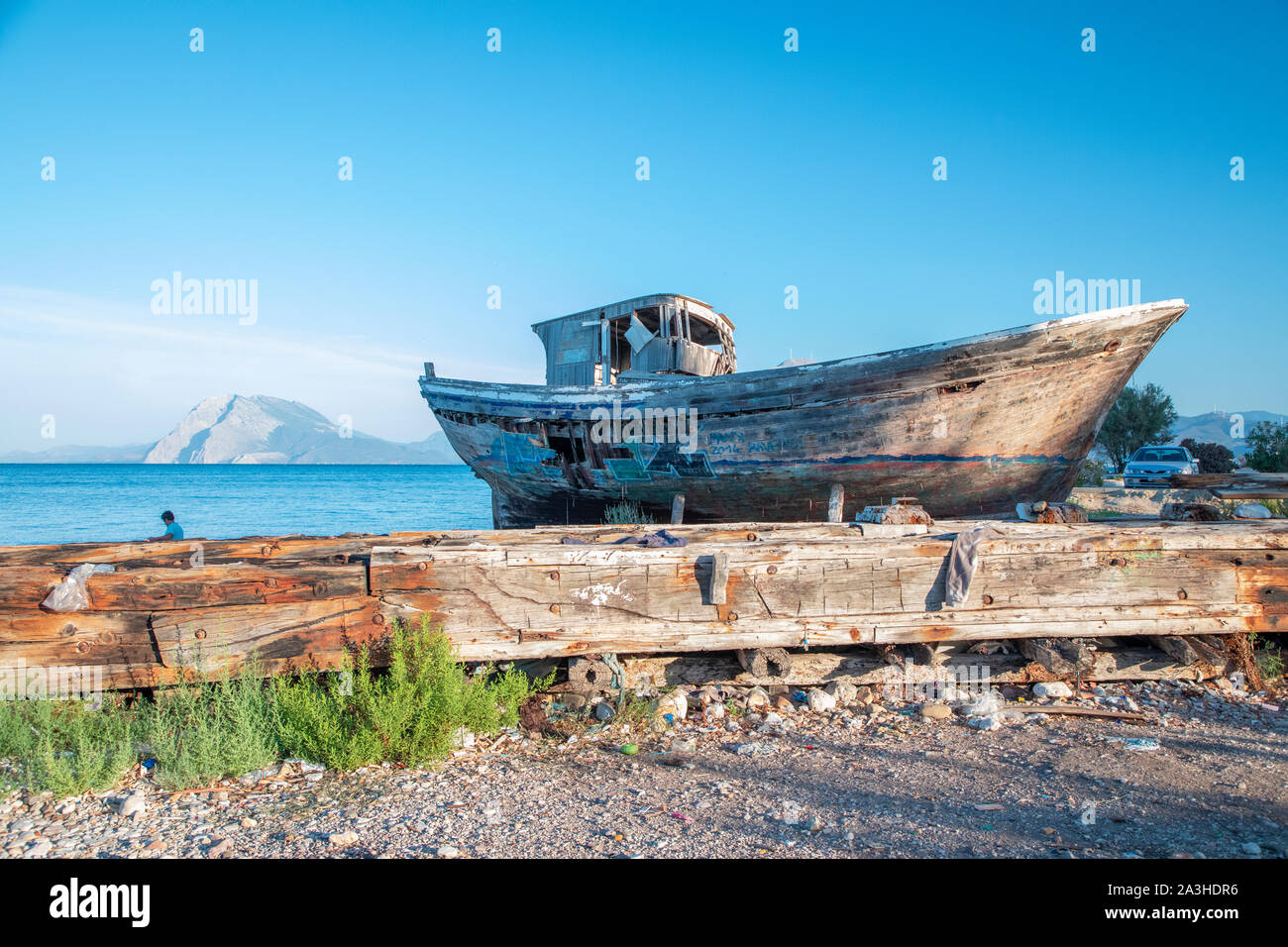 Un vieux bateau de pêche en bois couvert de graffitis sur cale sèche. Banque D'Images