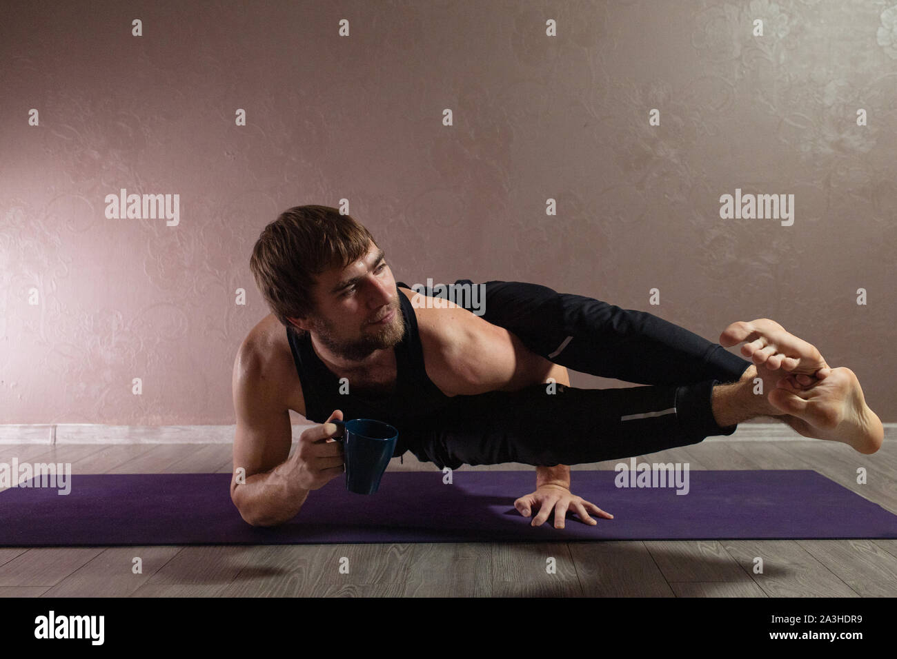 Jeune homme sportif pratiquant le yoga, méditation, yoga, le port de vêtements de sport, piscine pleine longueur, brown yoga studio Banque D'Images