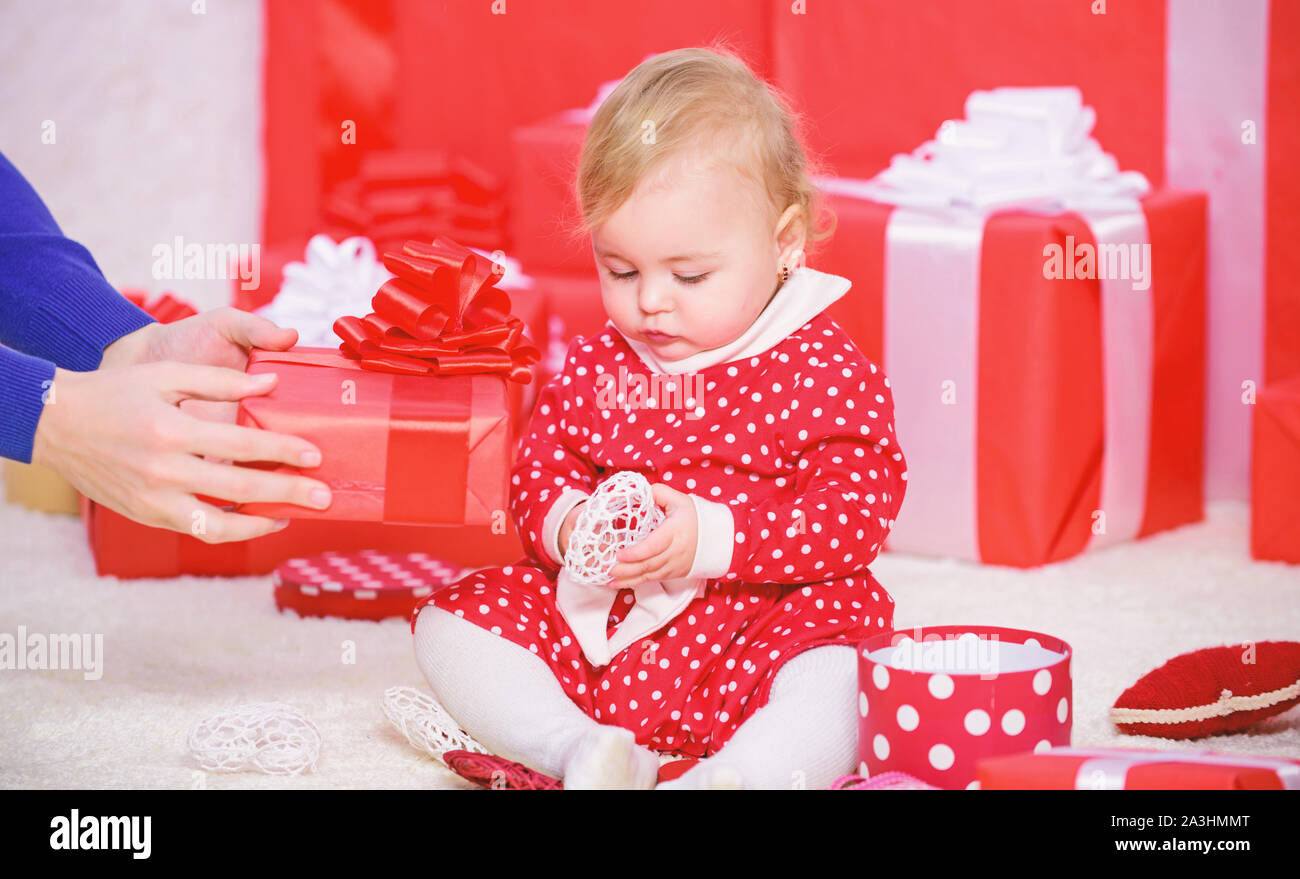 Mon premier noël. Partager la joie de Noël avec bébé première famille. Premier Noël de bébé, au cours de la vie, une fois l'événement. Petit bébé jouer près de tas de cadeaux rouge enveloppé. Cadeaux pour enfant premier noël. Banque D'Images