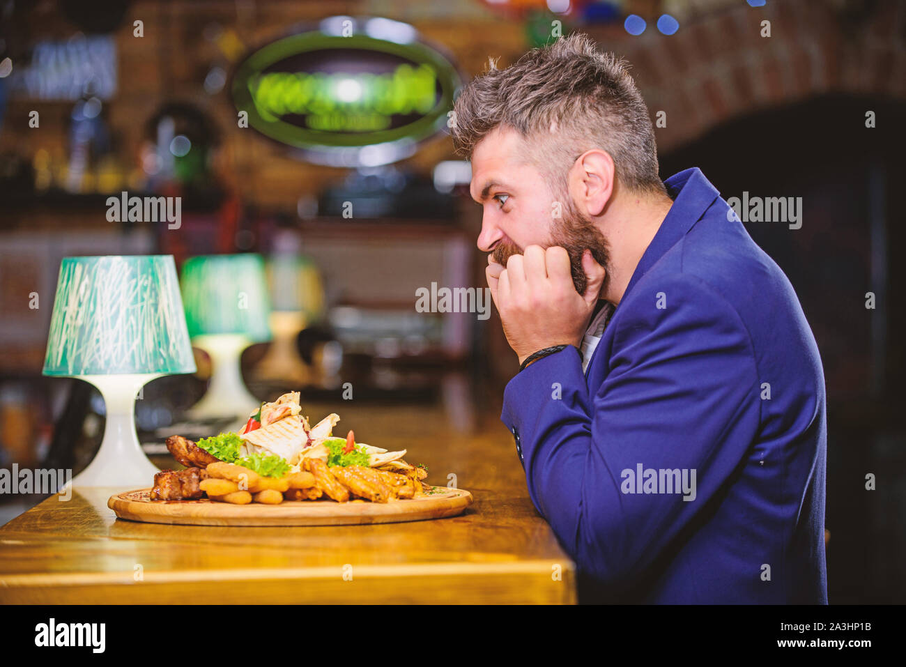 Profitez de repas. Des calories. Tricher repas. Hipster faim manger pub aliments frits. Costume officiel Gestionnaire de siéger au comptoir du bar. Délicieux repas. L'homme a reçu de pommes de terre frites repas avec les bâtonnets de poisson viande. Banque D'Images