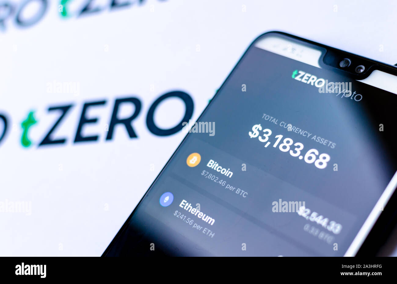 TZero logos sur la brochure et le smartphone avec l'application de chiffrement tZERO capture d'écran. Illustration photo éditoriale pour des nouvelles sur un nouveau portefeuille crypto. Banque D'Images