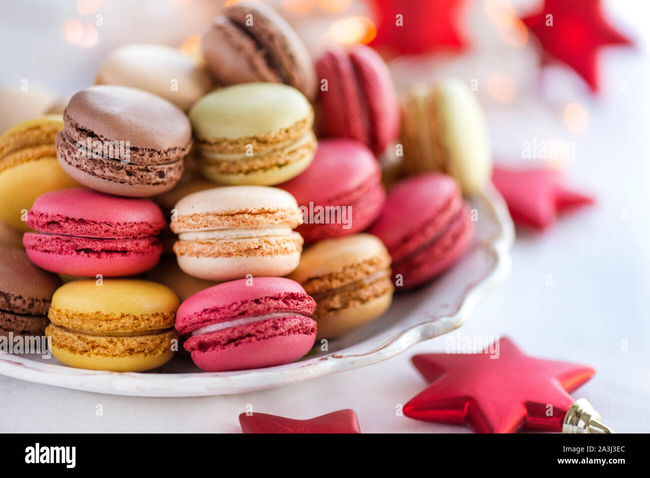 Assiette pleine de jolies macarons pastel avec fond de Noël Banque D'Images