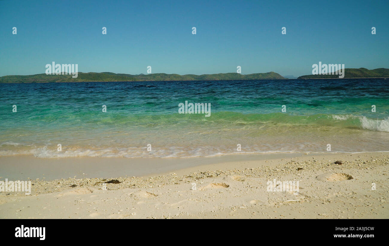 Plage de l'île et des vagues roulant sur le littoral. Malajon Island, Philippines, Palawan. Billet d'été et vacances. Banque D'Images