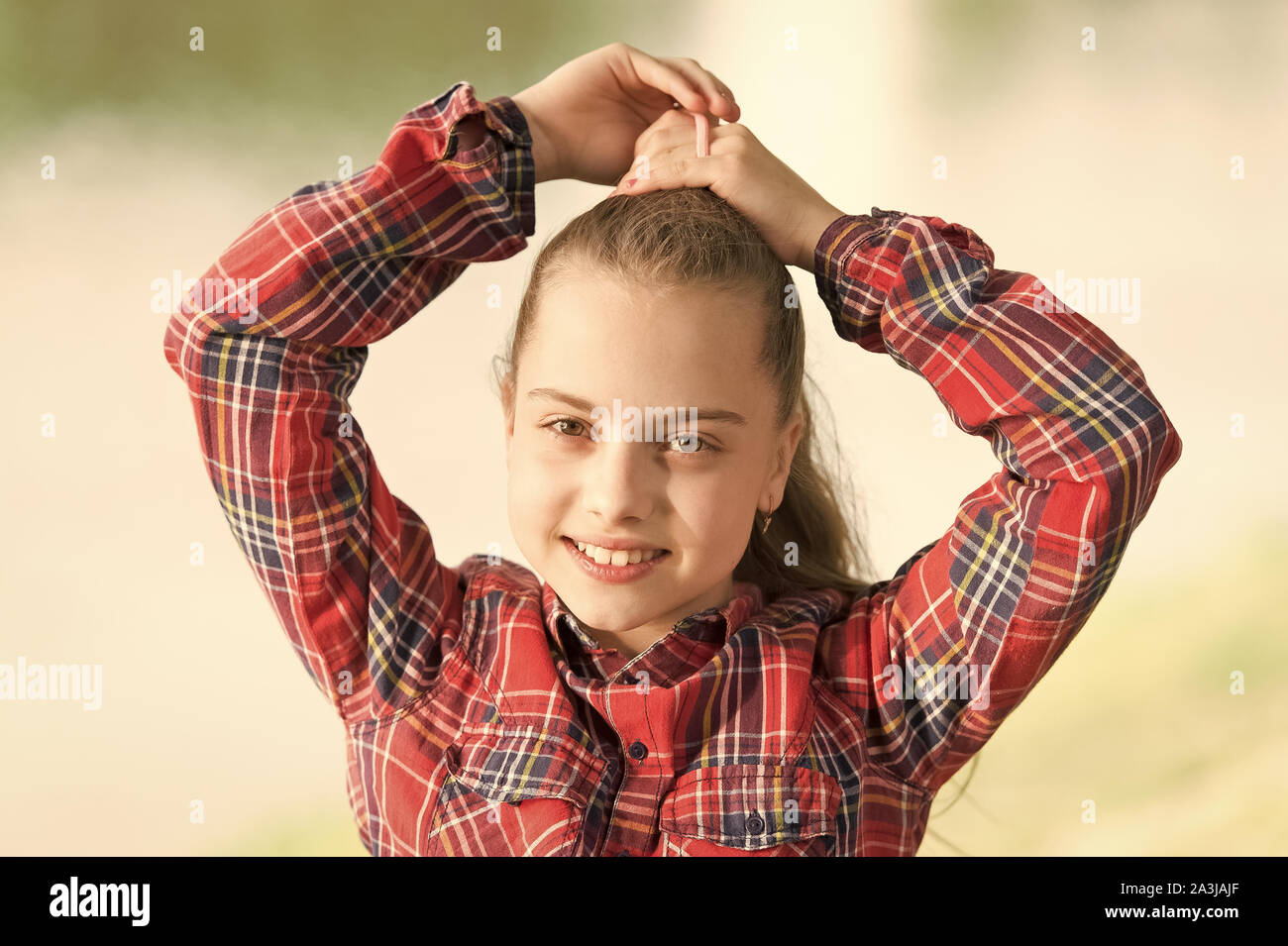 Coiffures à porter les jours de vent. Sentiment intime et confortable sur jour de vent. Traiter les cheveux longs sur jour de vent. Coiffures coupe-vent. Peu de fille cute child profitez à pied sur la nature de fond jour venteux. Banque D'Images