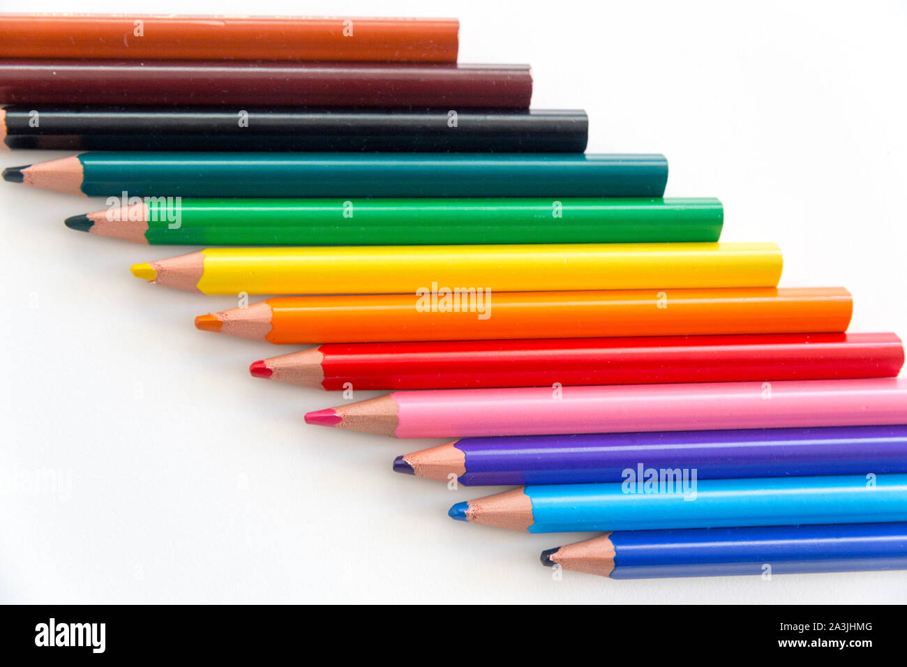 Vue de dessus d'une série de crayons de couleur en bois épais avec des conseils et élève, disposés en diagonale dans le cadre. Banque D'Images