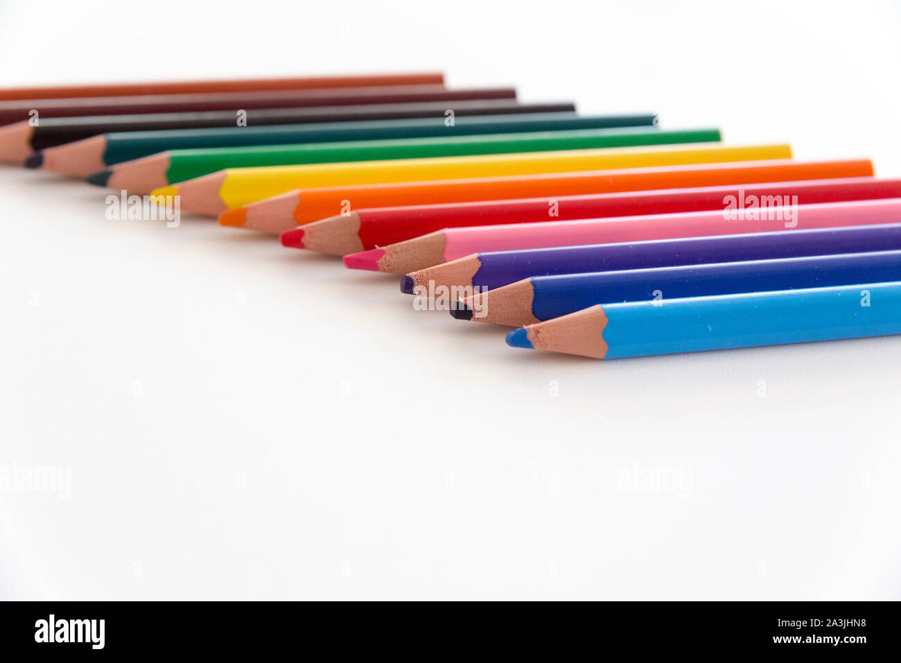 Selective focus close up d'un certain nombre de couleurs, de crayons épais avec des conseils à l'avant-plan, isolé sur blanc fond neutre. Banque D'Images