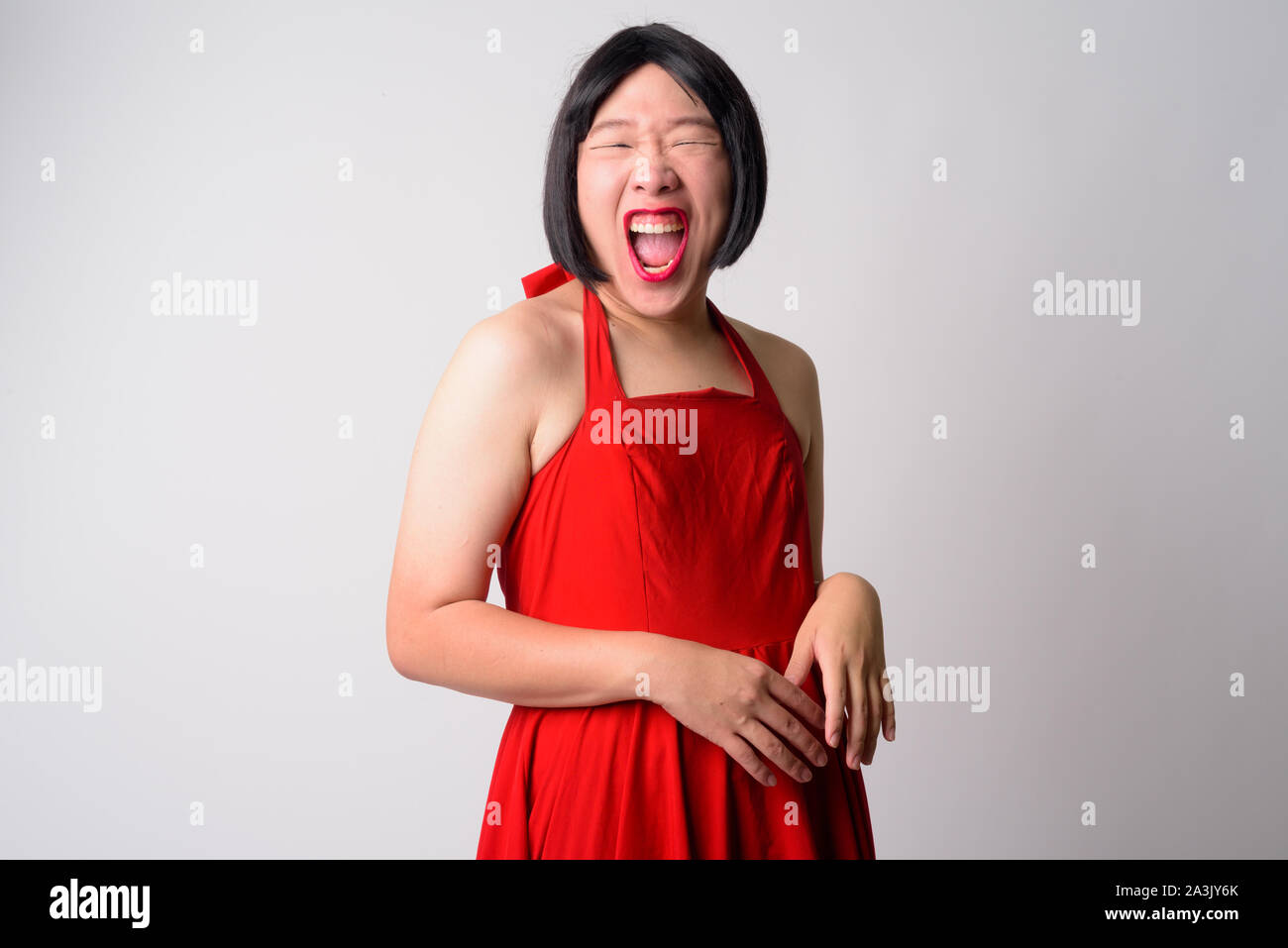 Portrait of happy young gay Asian man laughing at camera Banque D'Images