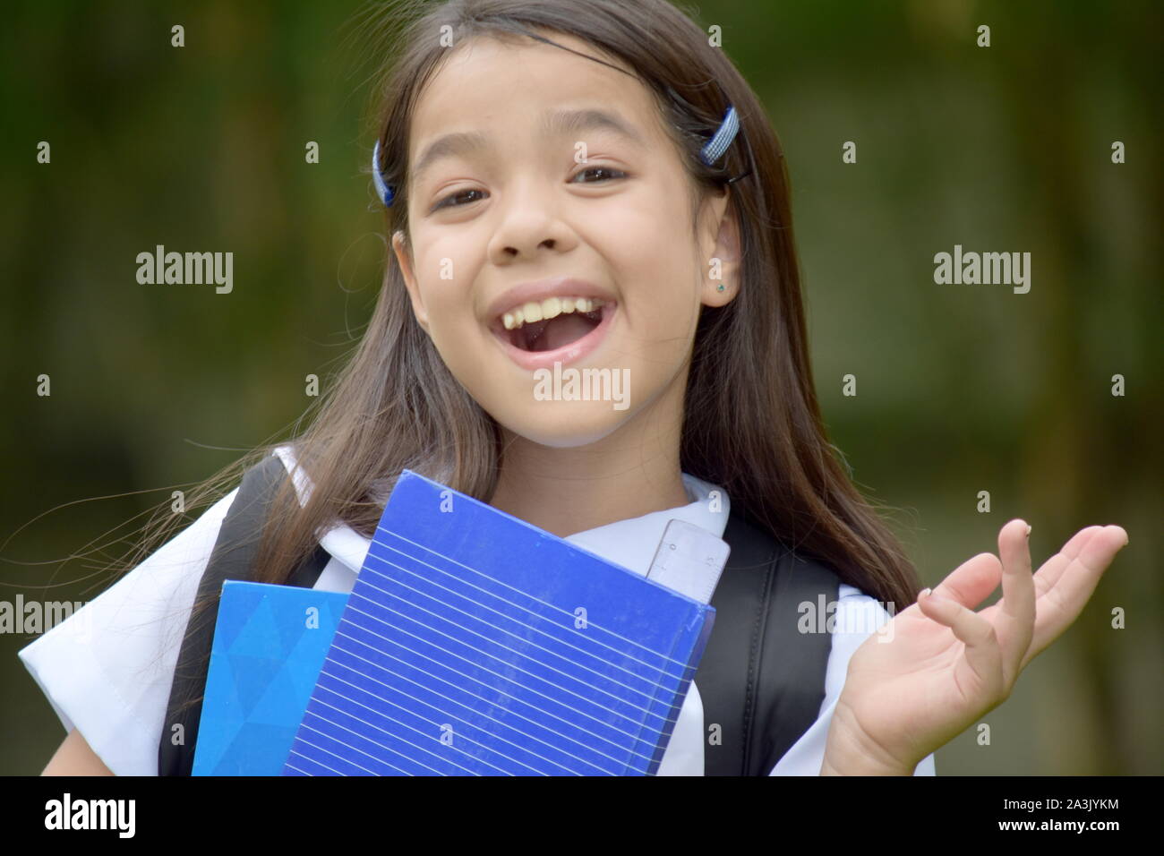 Jolie Fille de l'école et le bonheur de porter l'uniforme scolaire avec des livres Banque D'Images
