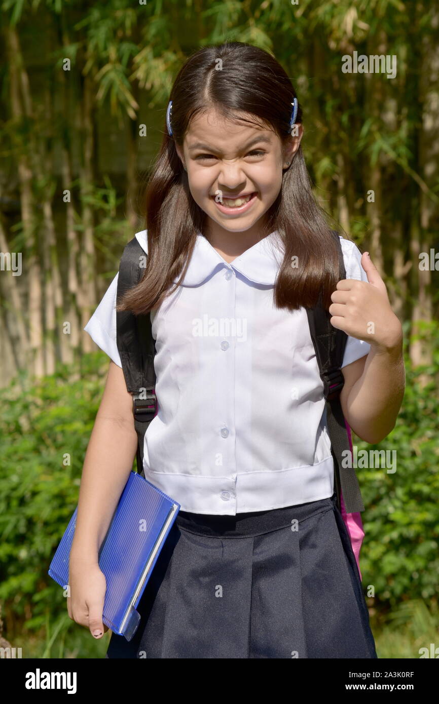Fille de l'école prép anxieux portant l'uniforme scolaire avec les ordinateurs portables Banque D'Images