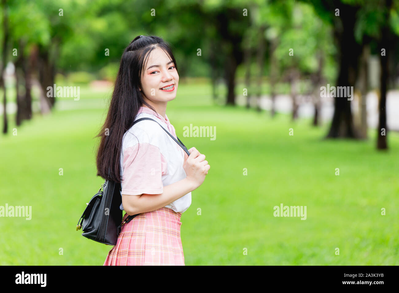 Asian teen girl smiling with braces dents happy travel outdoor à Green Park background Banque D'Images