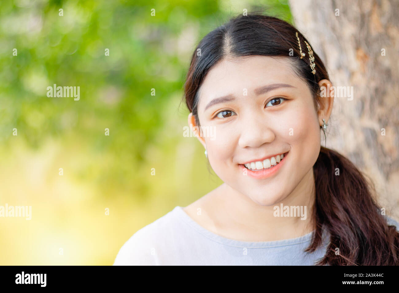 Belle innocents cute girl smiling dents sain forme corpulent race asiatique outdoor vert nature. Banque D'Images