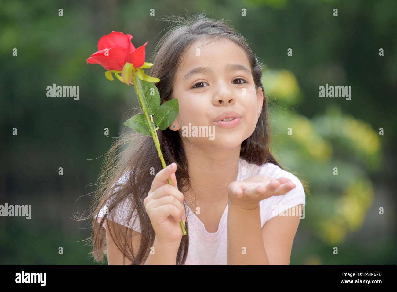 Girl Blowing Kisses avec une rose Banque D'Images