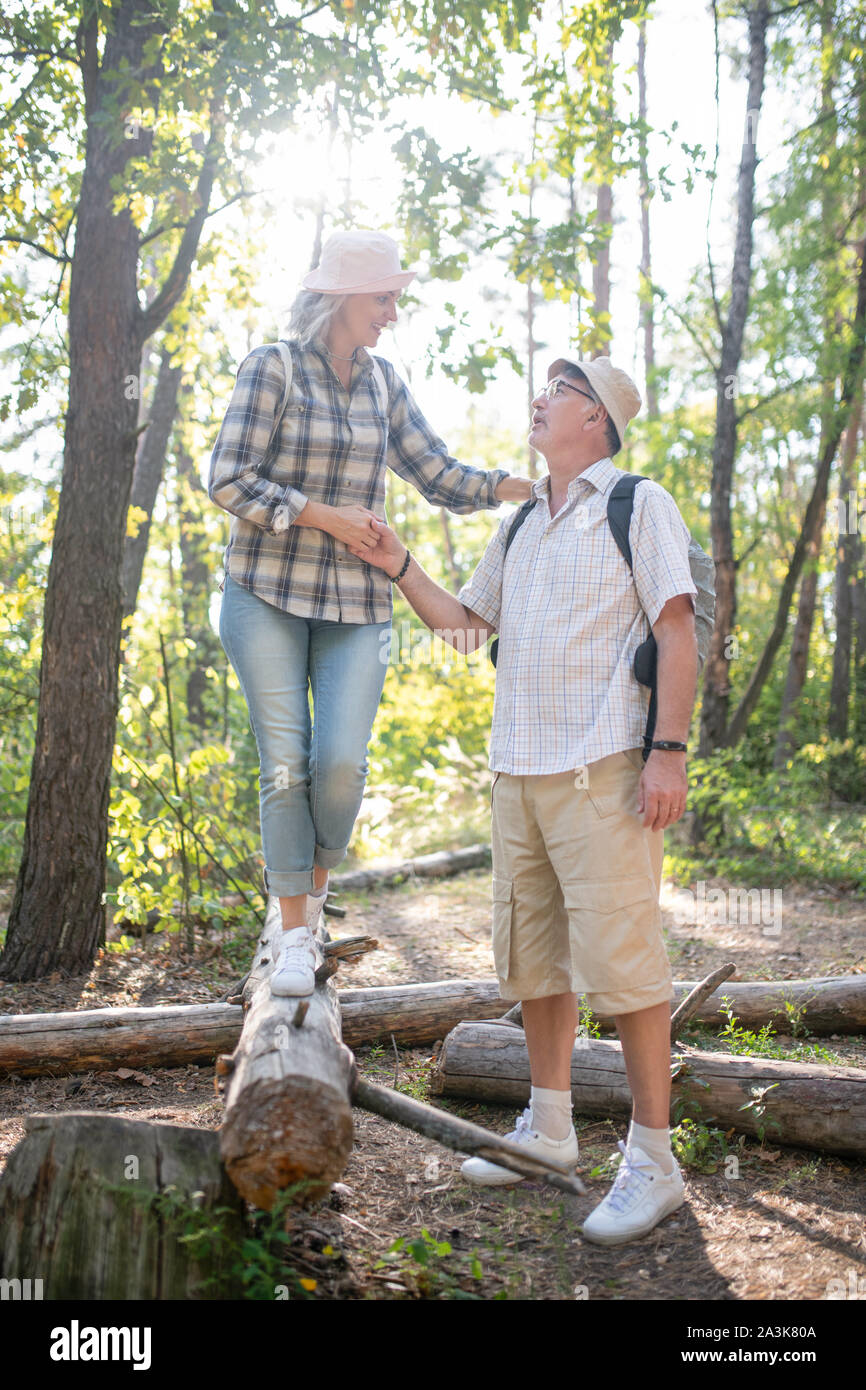 Couple de touristes matures porter un chapeau marcher en forêt Banque D'Images