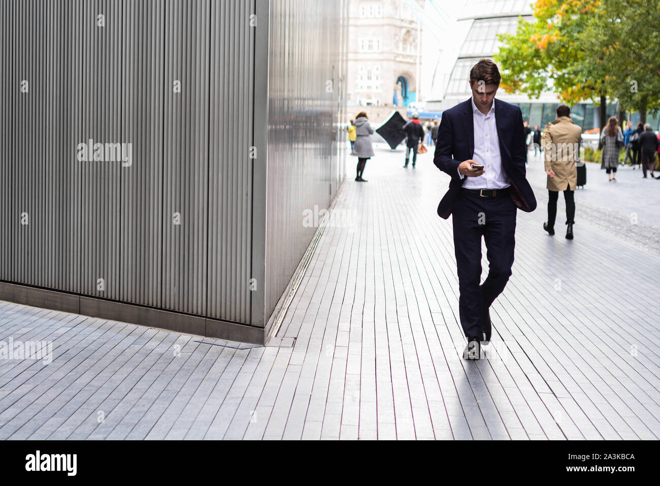 Des gens habillés dans des tenues élégantes de style d'affaires marche dans des emplois de bureau, près de Tower Bridge à Londres Banque D'Images