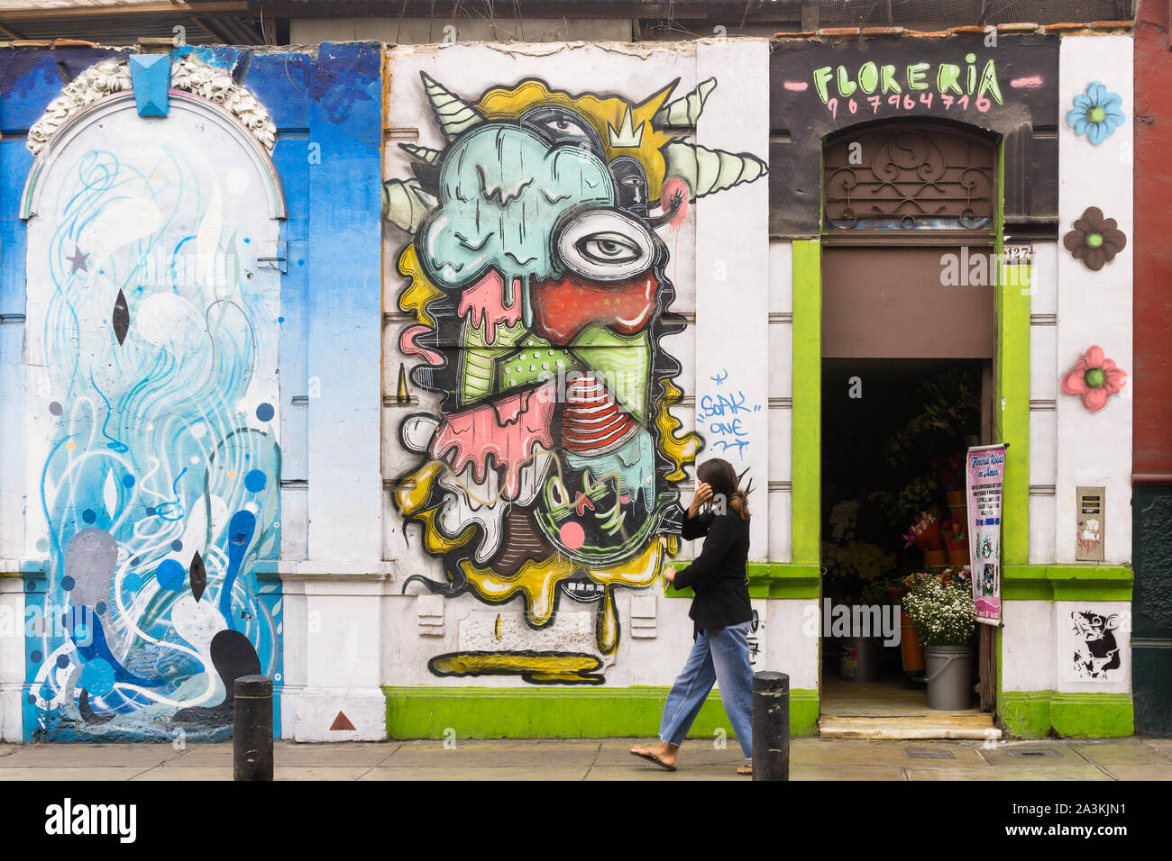 Barranco Lima street art - femme devant un mur décoré de graffiti dans le district de Barranco Lima, Pérou, Amérique du Sud. Banque D'Images