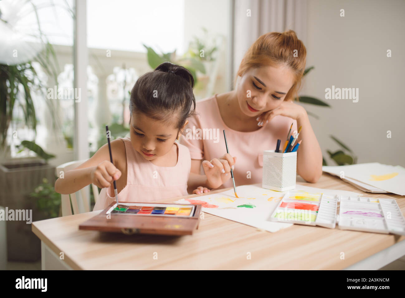 Jeune asiatique belle maman avec sa fille peinture pour enfants à la maison. Banque D'Images