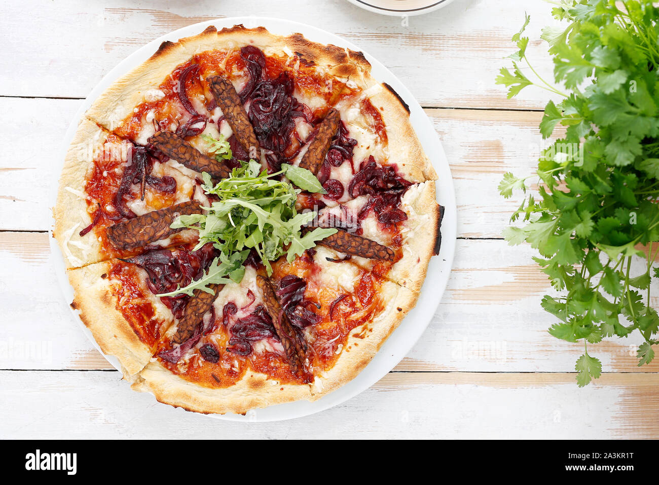 Pizza végétarienne avec sauce tomate, le tempeh fumé et oignons rouges. Banque D'Images