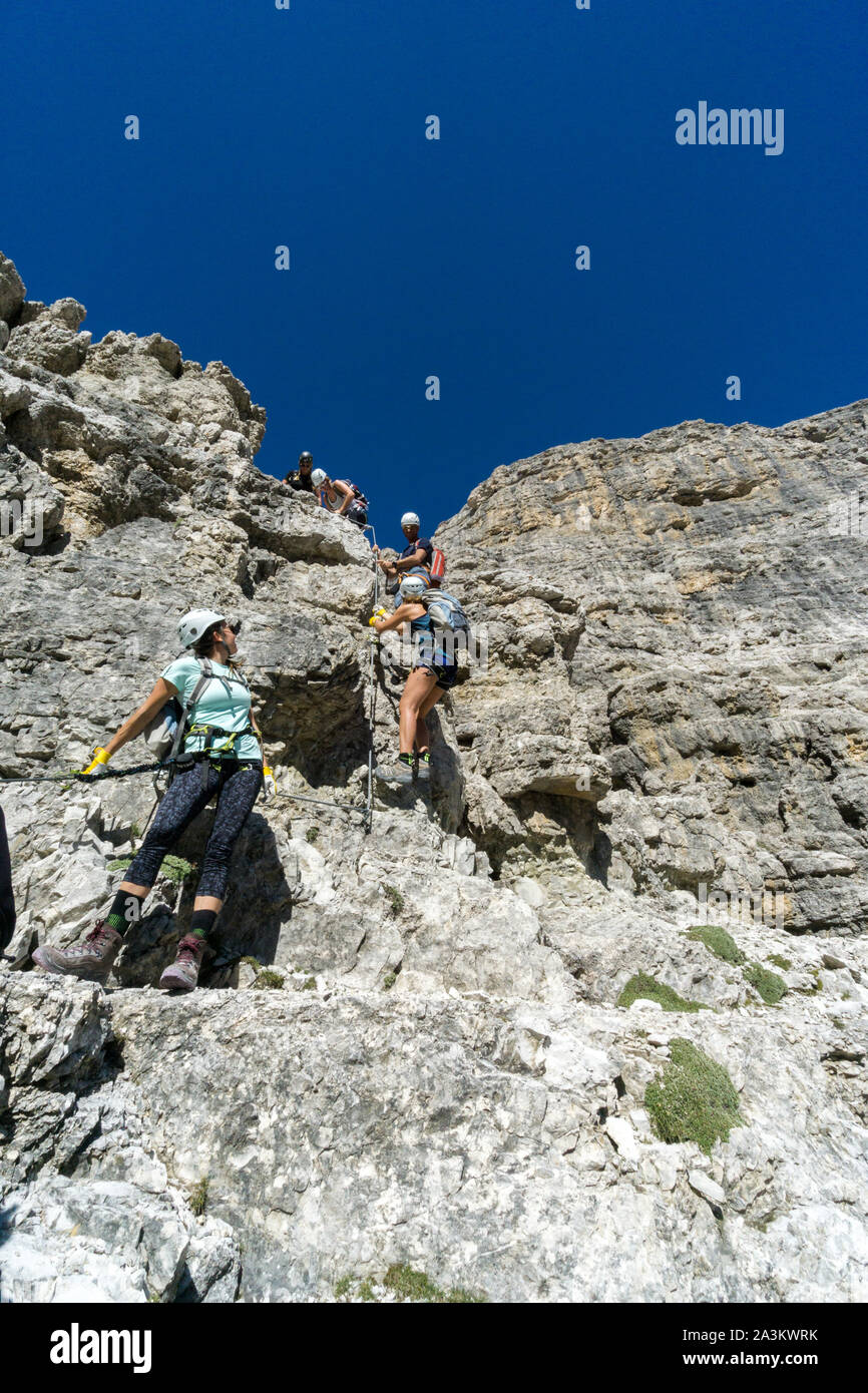 Un guide de montagne et plusieurs clients l'ascension d'une via ferrata dans les Dolomites Italaian Banque D'Images