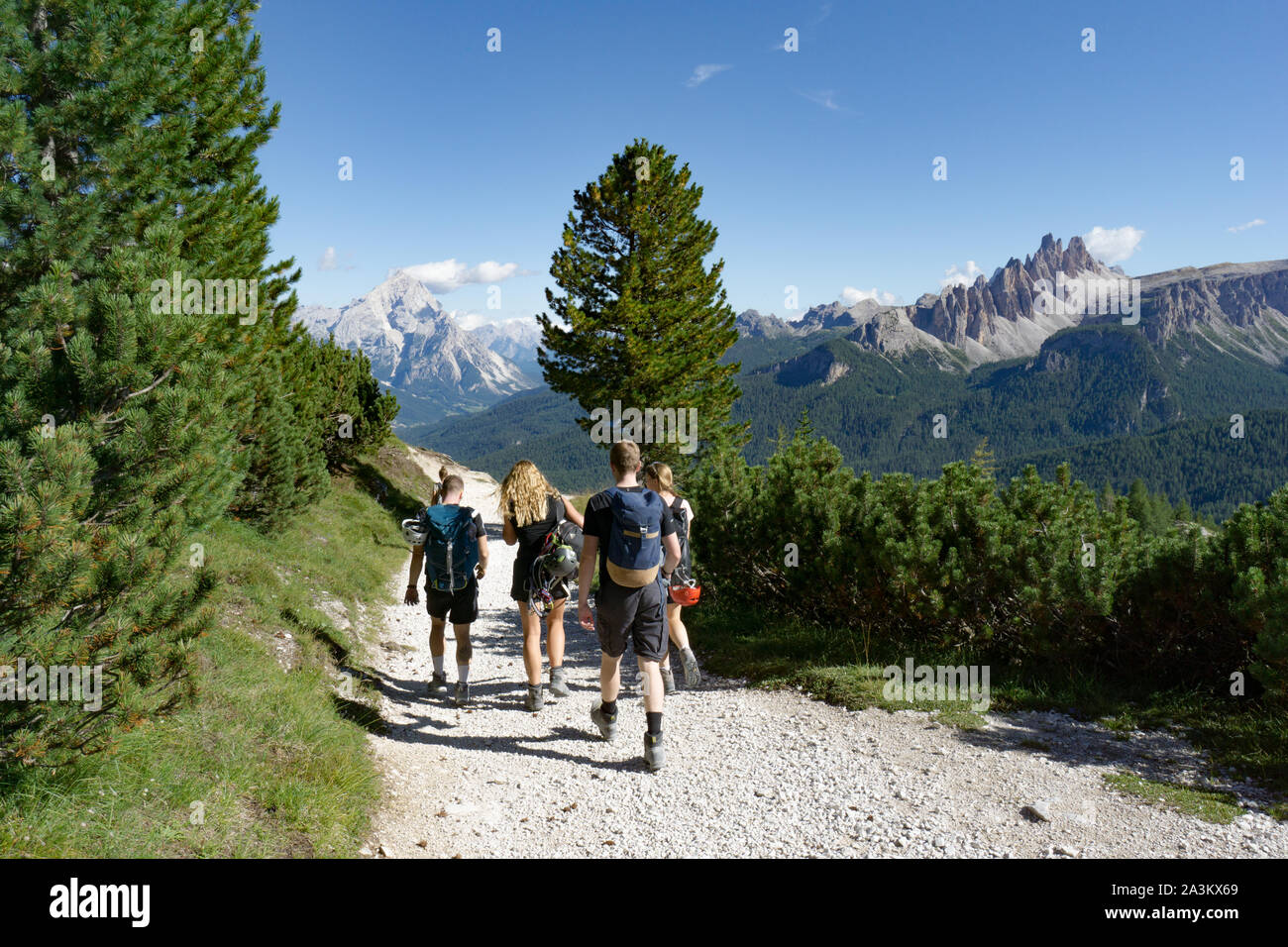 Les grimpeurs marchant sur une route dans un paysage de montagne Dolomites après une dure ascension avec une magnifique vue panoramique derrière eux des montagnes de l'Alta Badia Banque D'Images