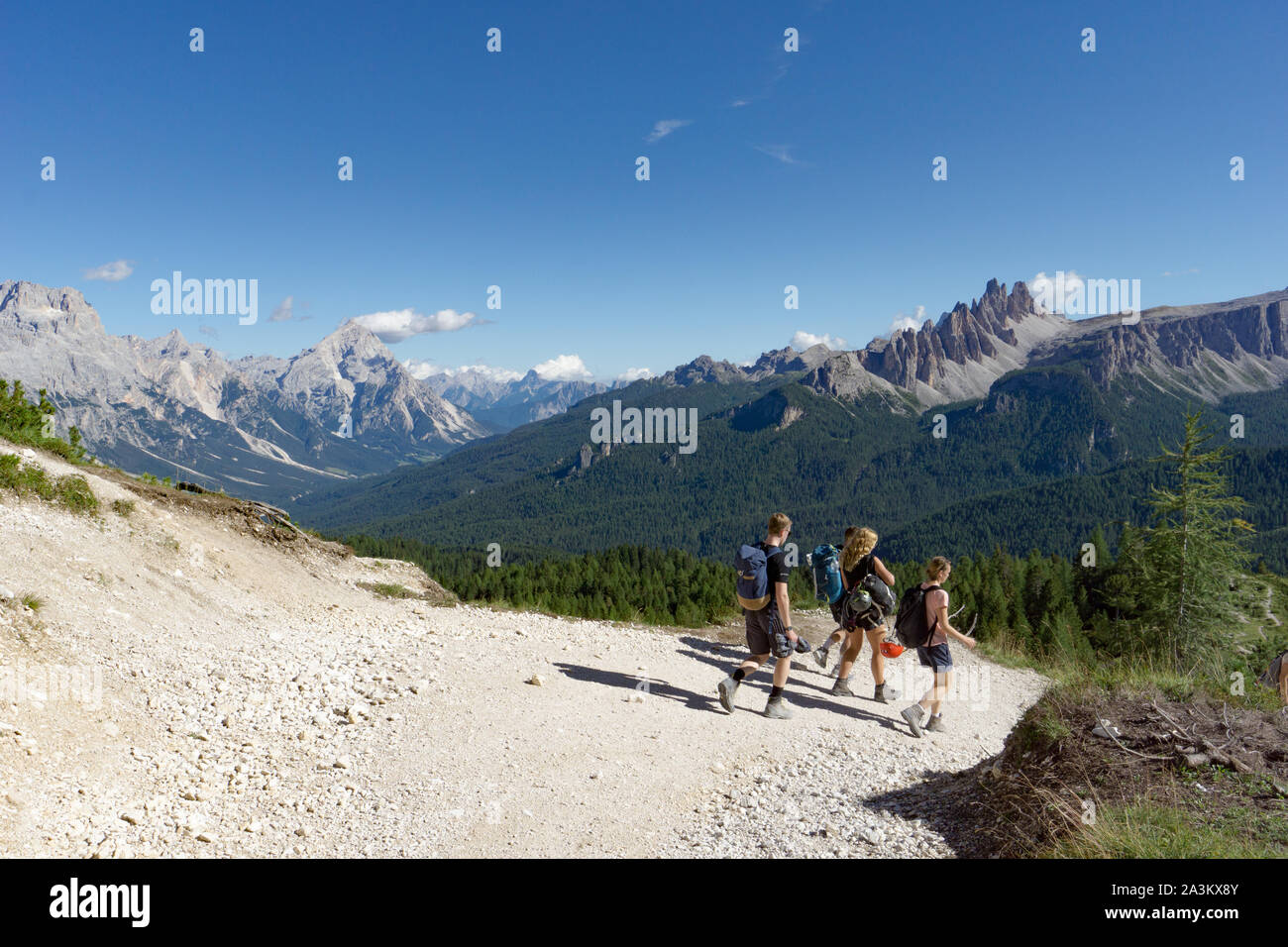 Les grimpeurs marchant sur une route dans un paysage de montagne Dolomites après une dure ascension avec une magnifique vue panoramique derrière eux des montagnes de l'Alta Badia Banque D'Images