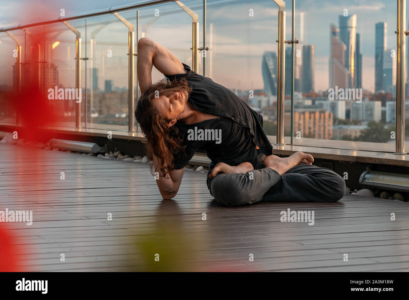Man practicing yoga athlétique attrayant dans le centre d'affaires avec une belle vue sur une ville de gratte-ciel. Young et méditant à diner Banque D'Images
