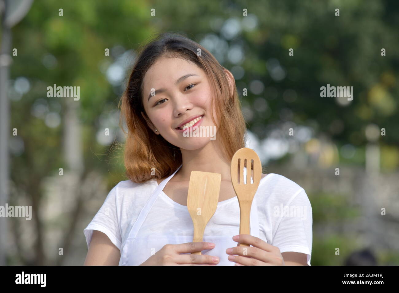 Femme cuisinière et ustensiles avec bonheur Banque D'Images