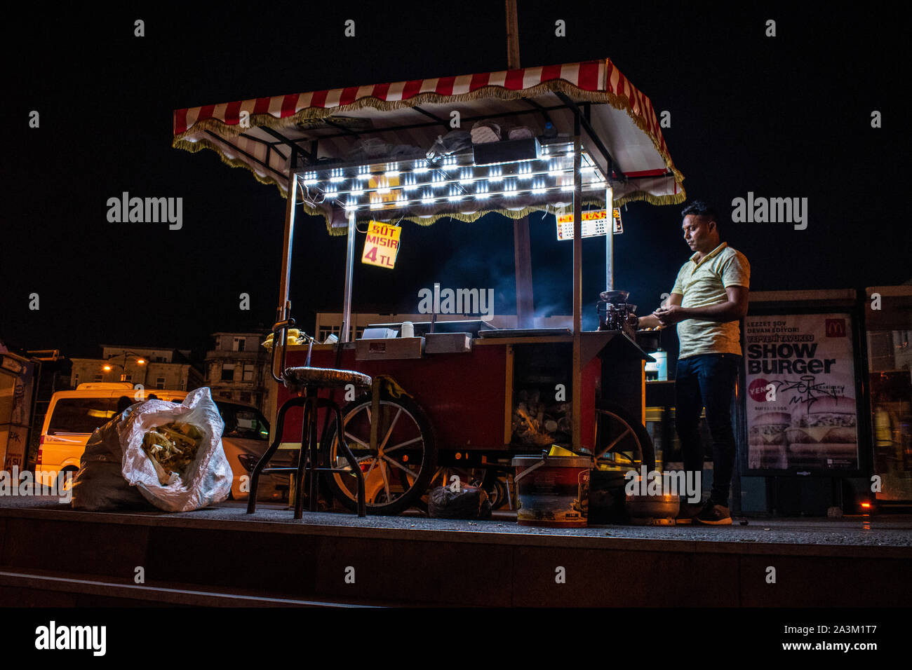Istanbul : la vie nocturne dans la ville et de l'alimentation de rue, un vendeur de maïs bouilli et rôti avec son kiosque à rayures rouges et blanches dans les rues d'Istanbul Banque D'Images